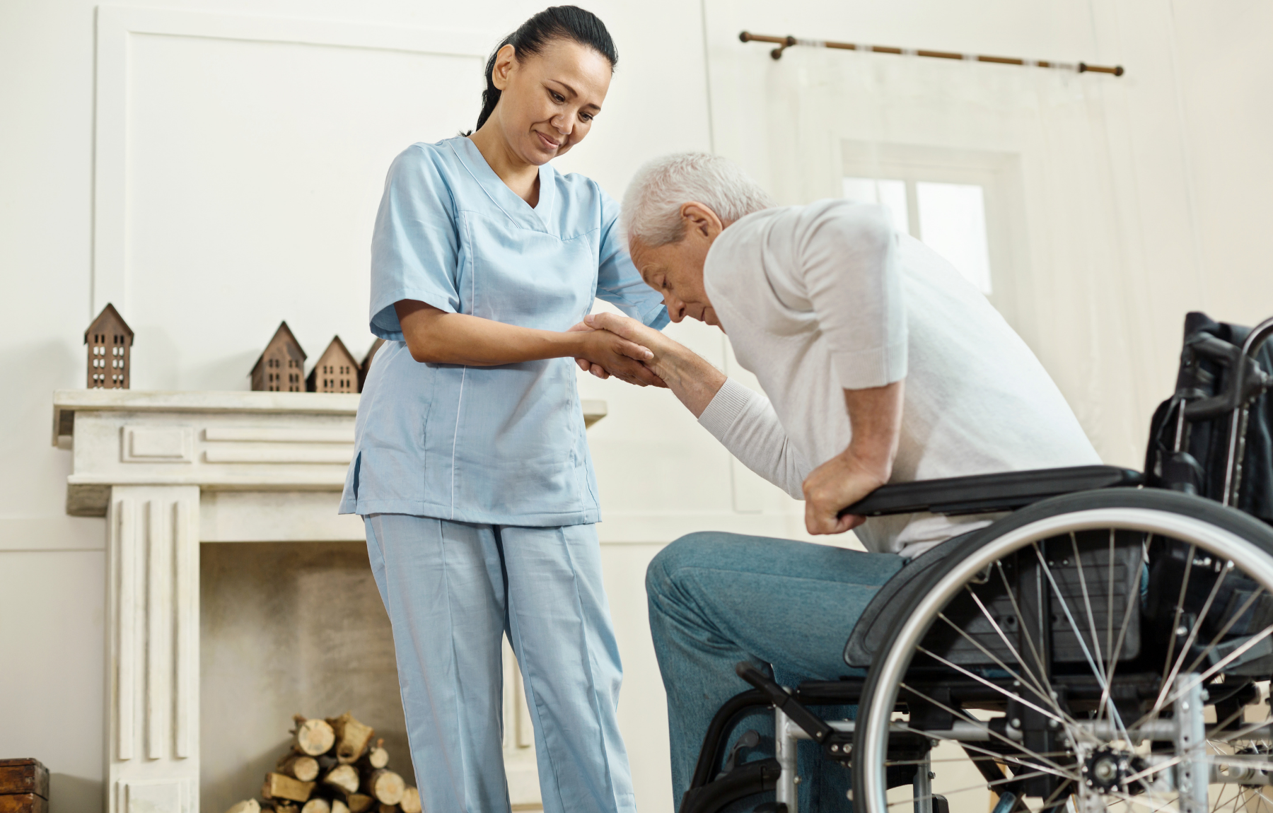 Smiling nurse helps senior man stand up from wheelchair