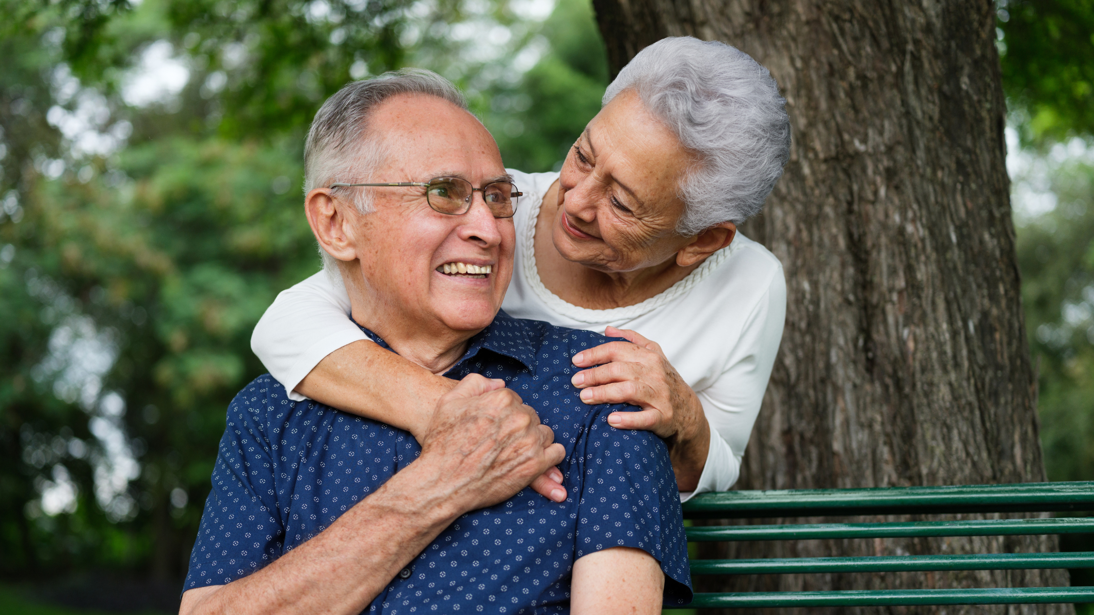 smiling senior couple under a tree