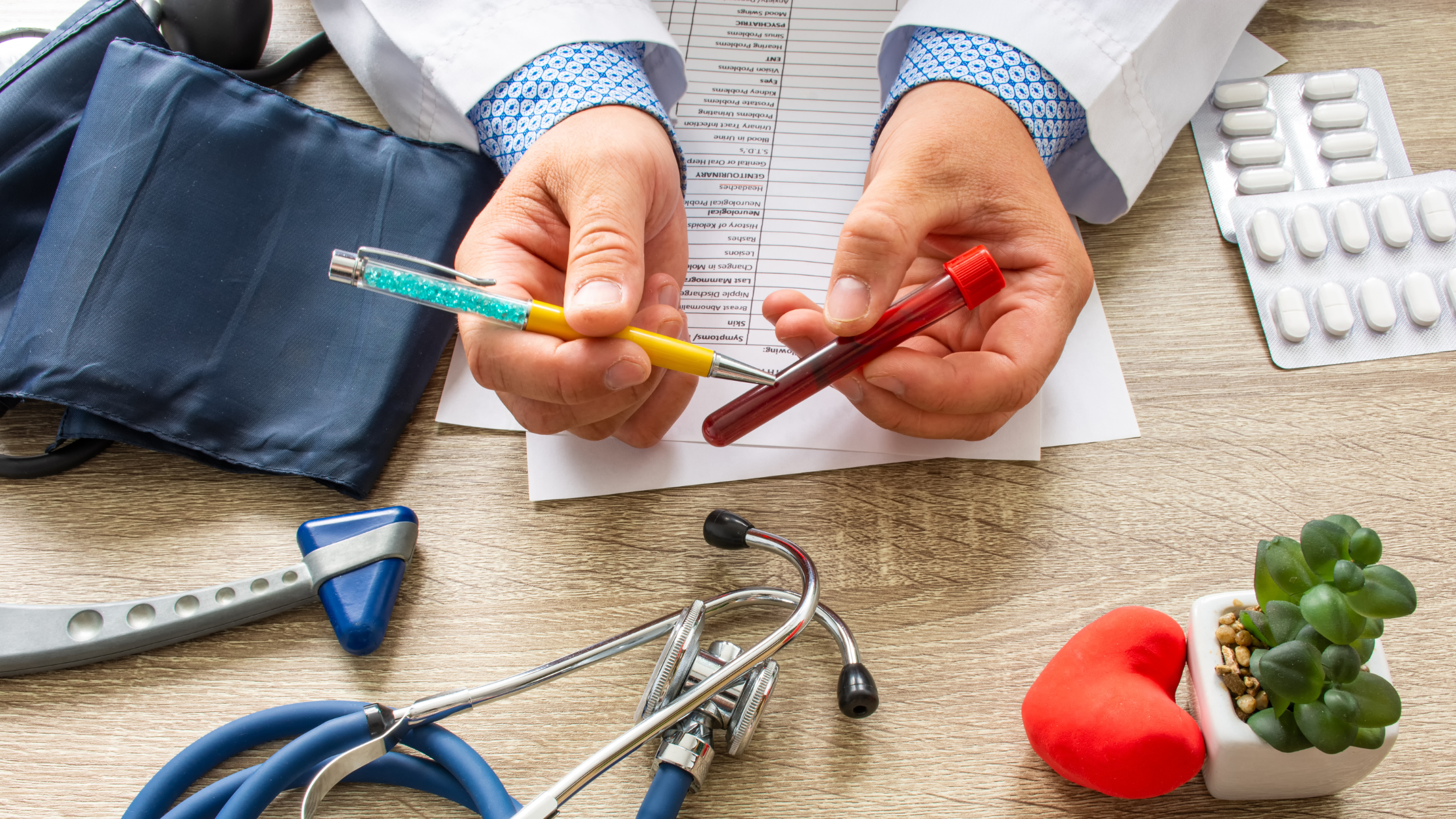 doctor holds a vial of blood over a messy desk