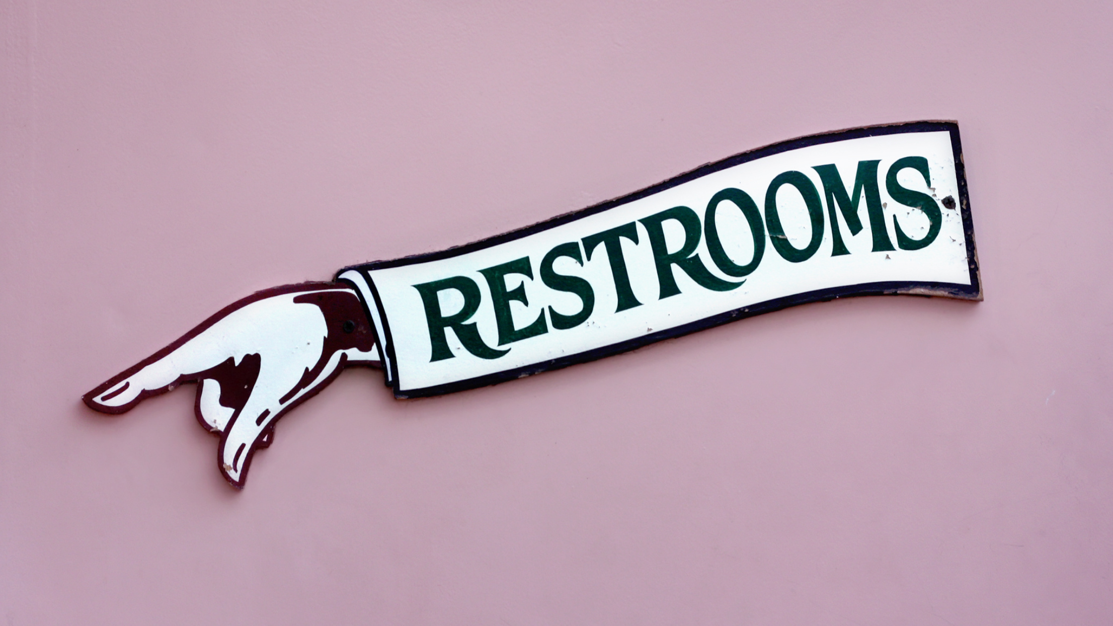 sign of a hand pointing that reads "Restrooms"