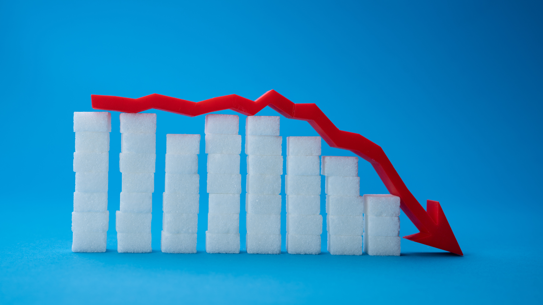 stacks of sugar cubes with a superimposed line trending downwards