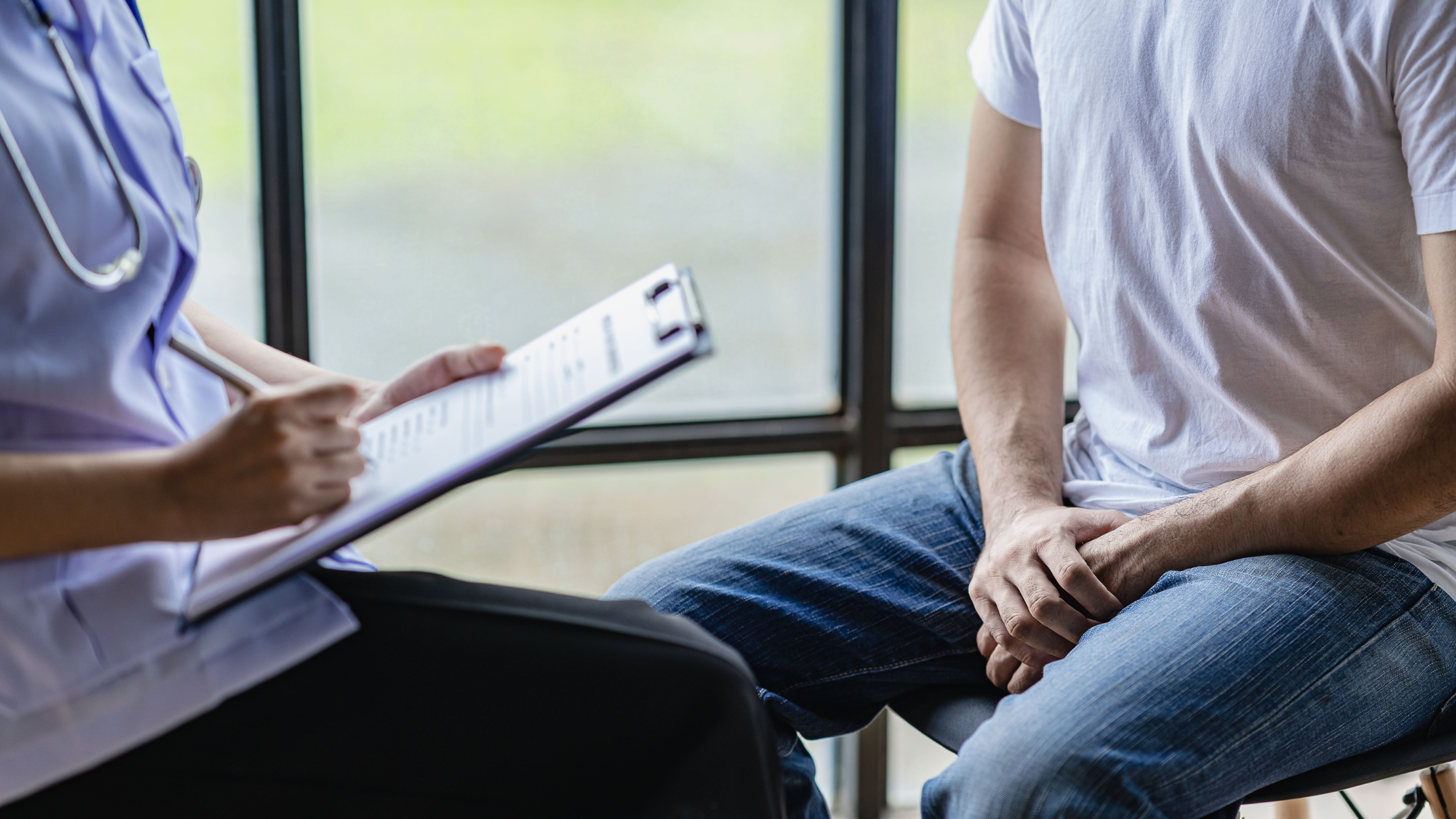 torso shot of two people sitting deep in conversation around a clipboard