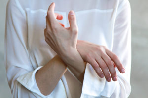 Person holds arm indicating arthritis pain