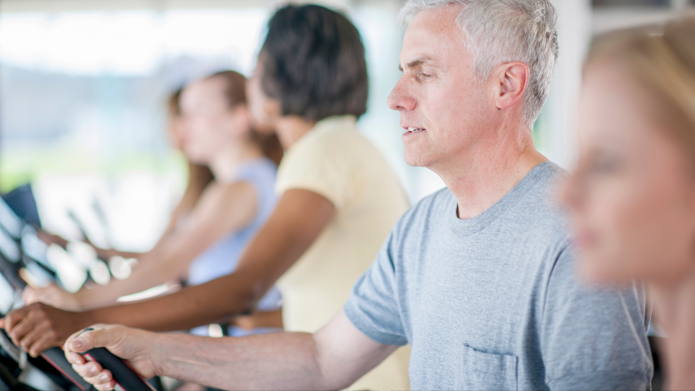 line of adults on stationary bikes
