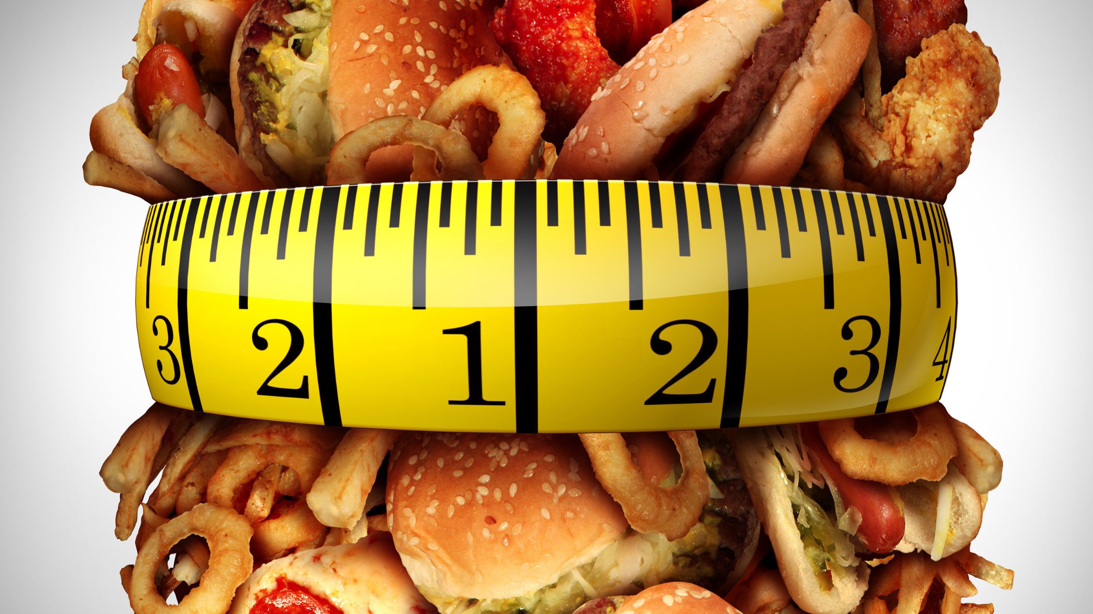 measuring tape pulling tight around a bundle of junk food