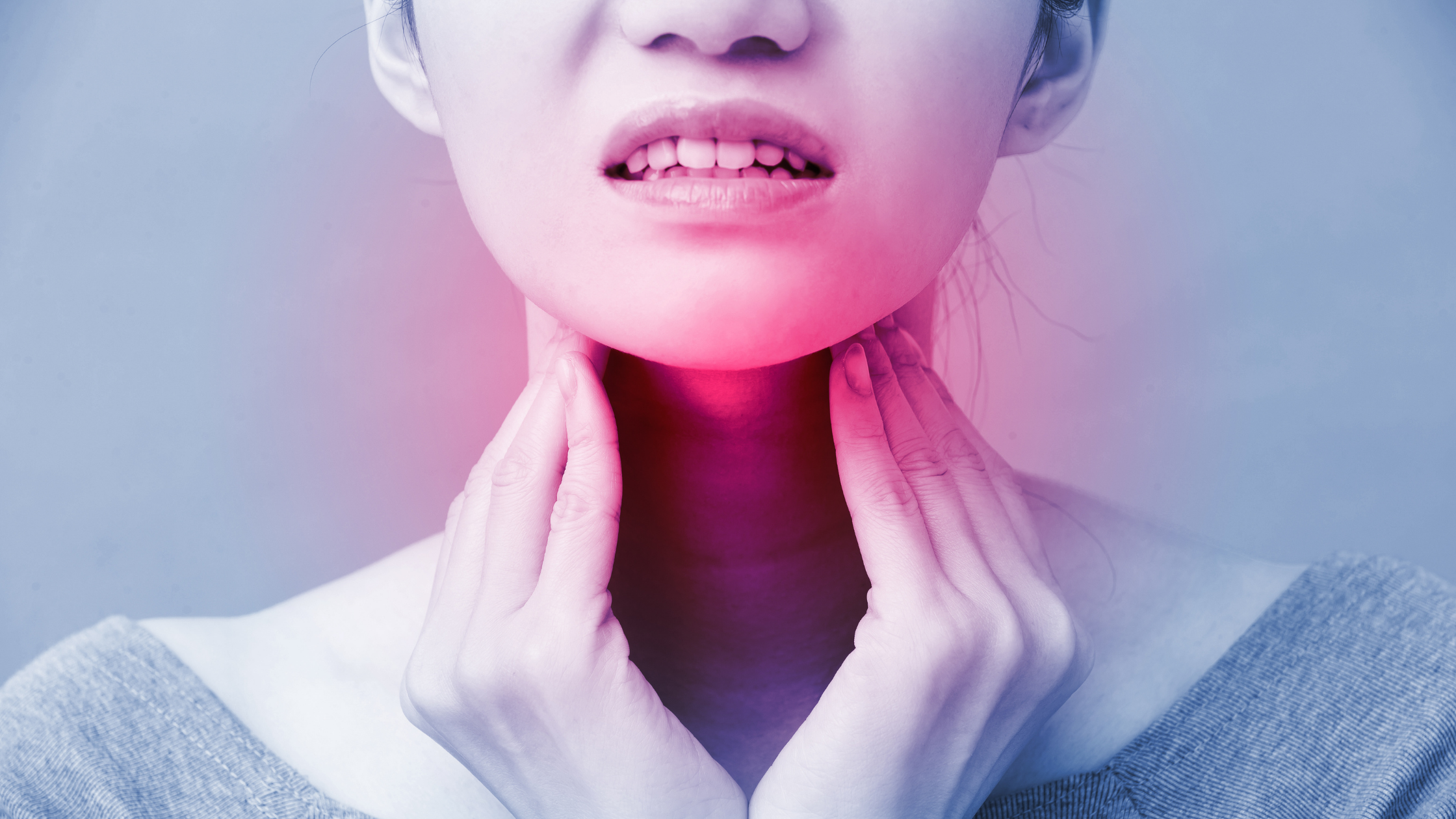 Woman massages throat in discomfort