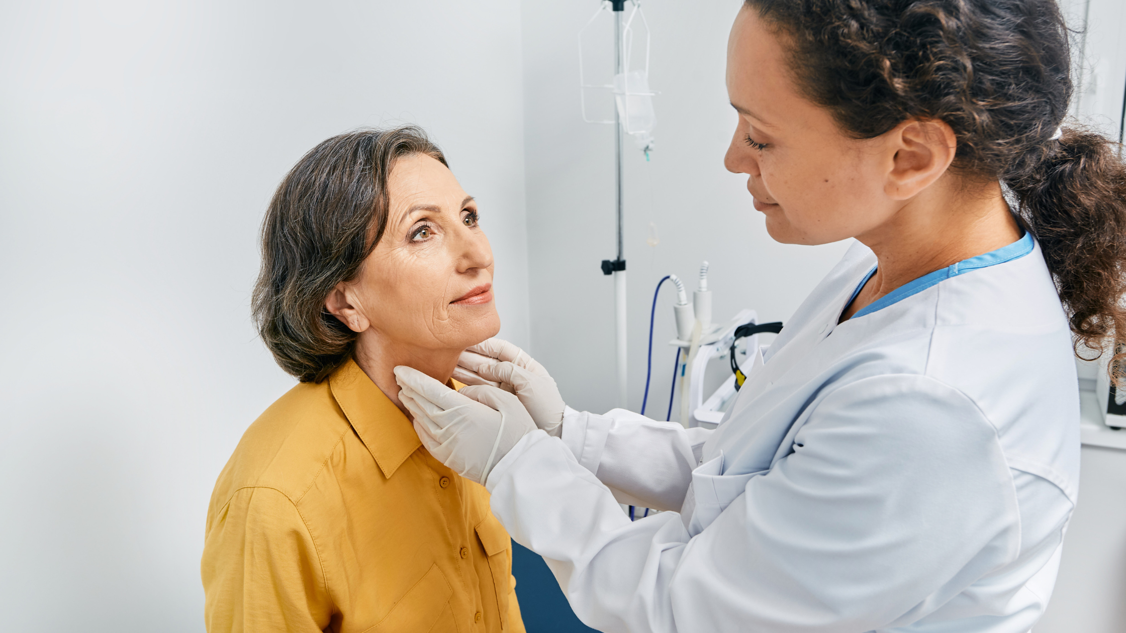 a doctor checks their patient's thyroid glans for swelling