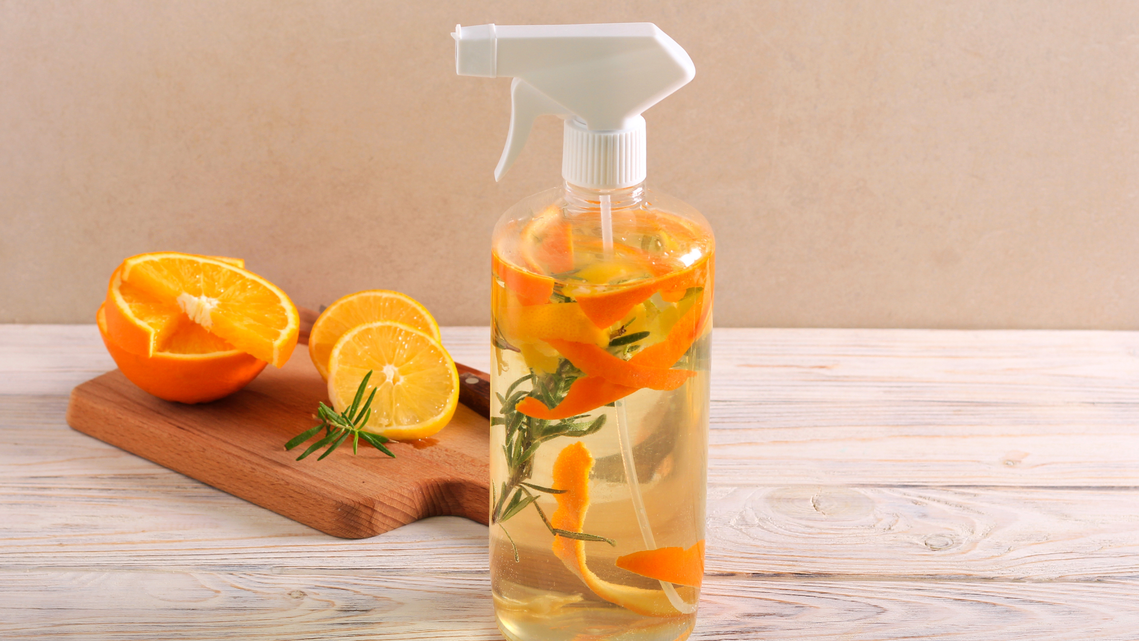 homemade cleaning spray with oranges in a clear reusable spray bottle