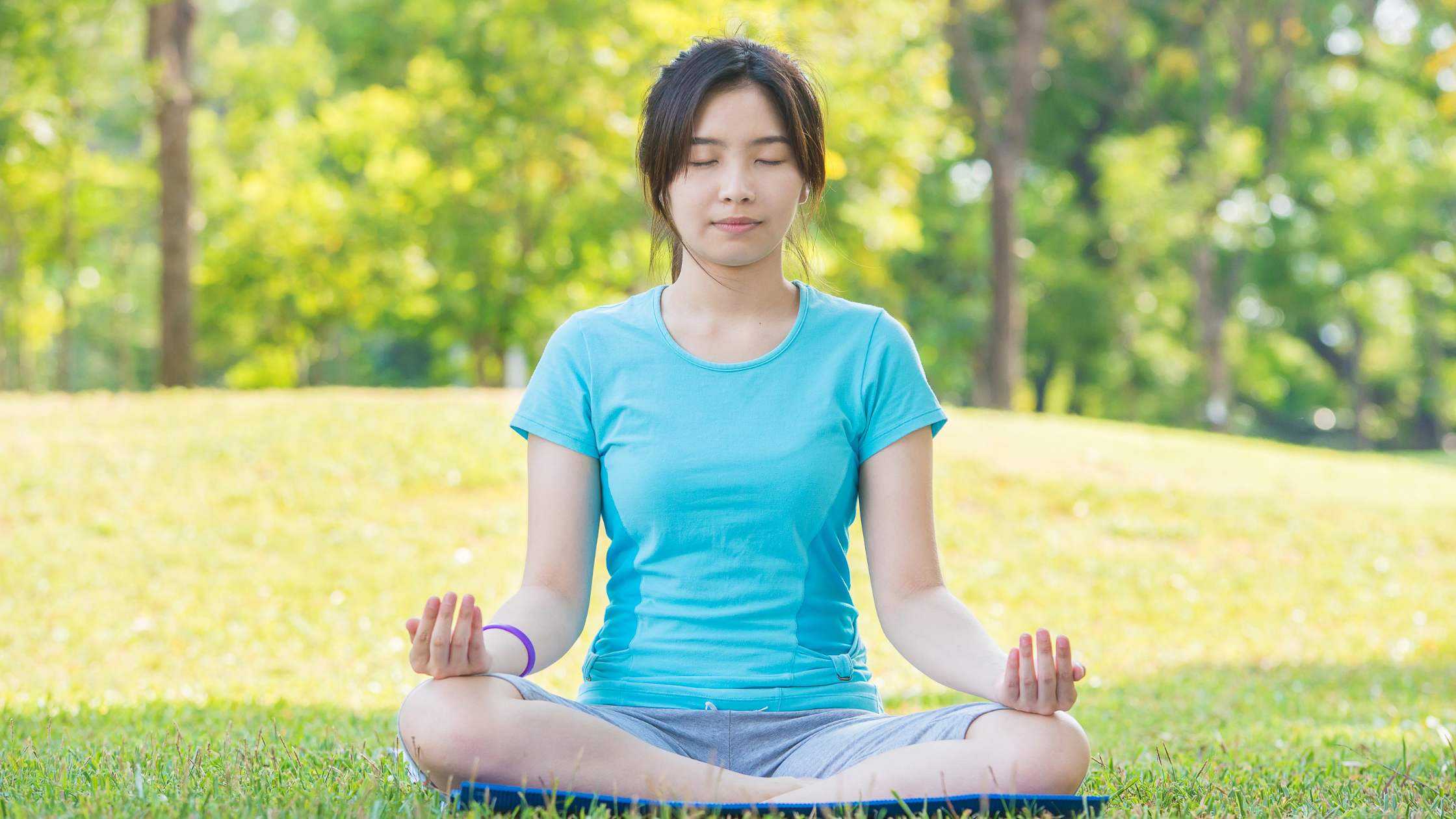 Woman meditating peacefully in the park