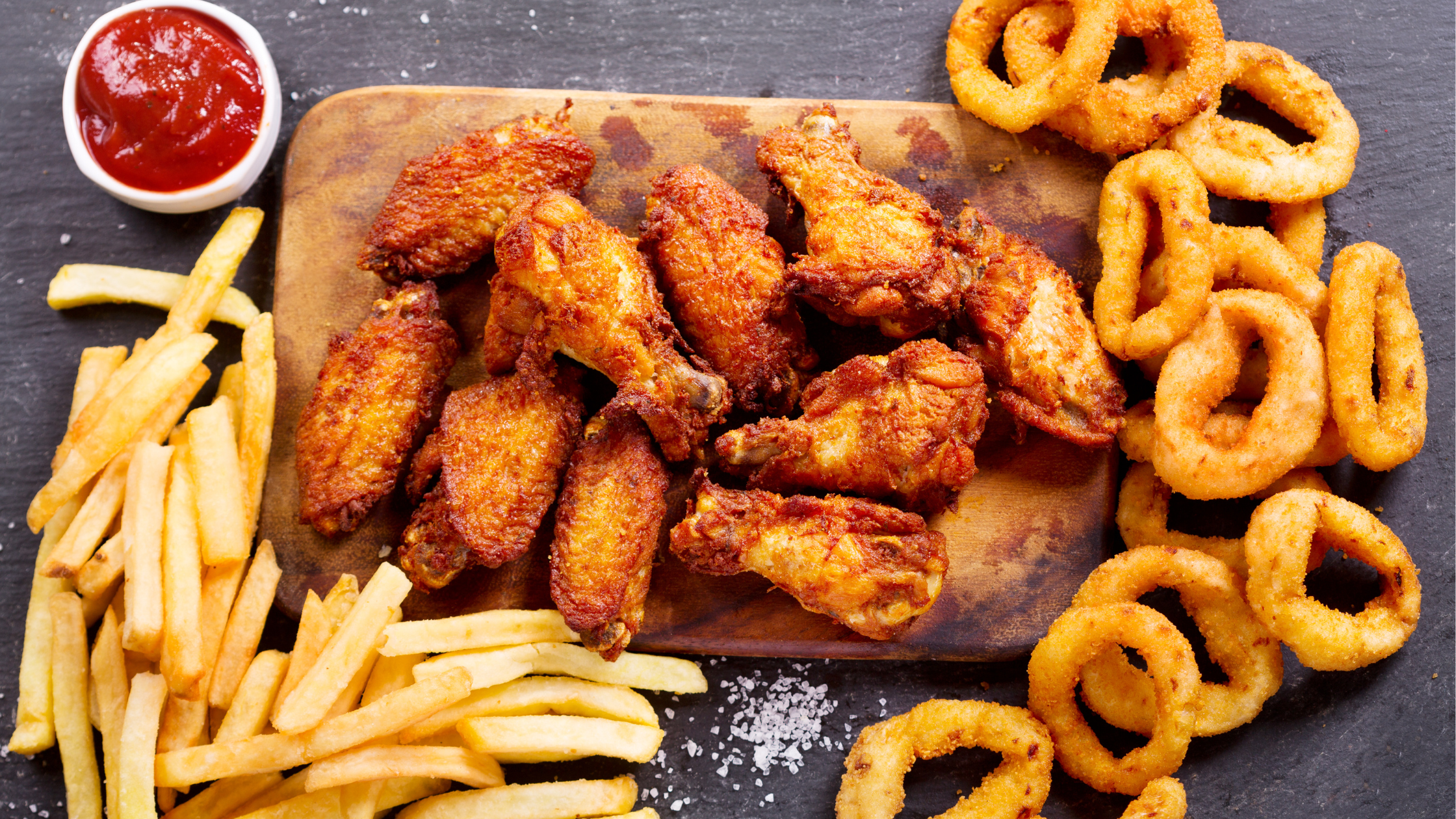 top-down view of french fries, wings, and onion rings