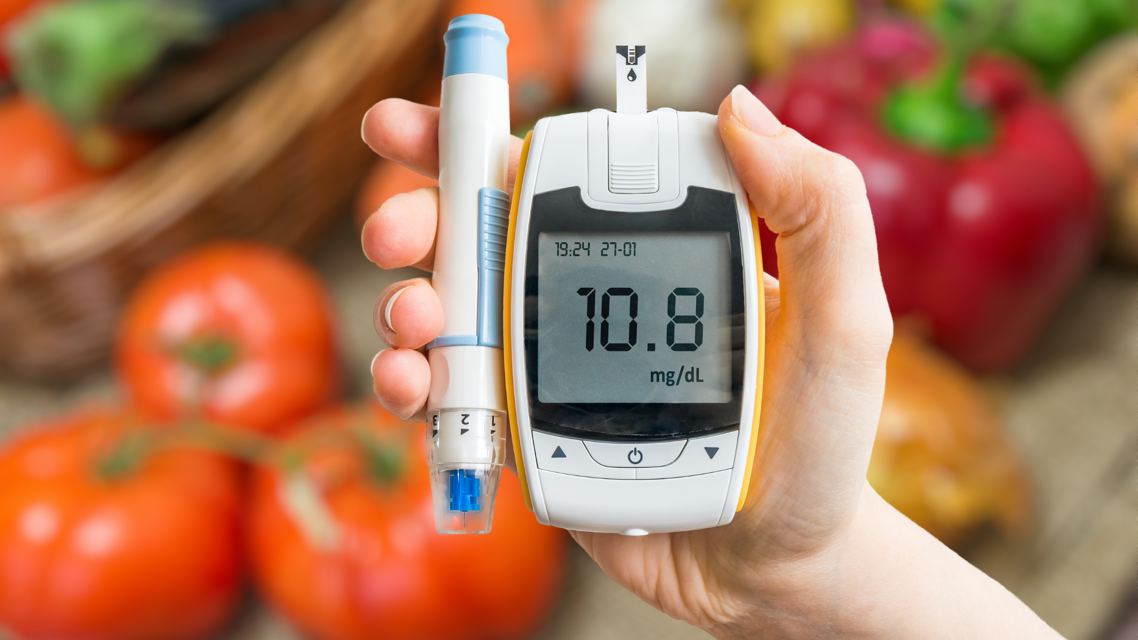 hand holding a diabetes blood sugar monitor and test kit