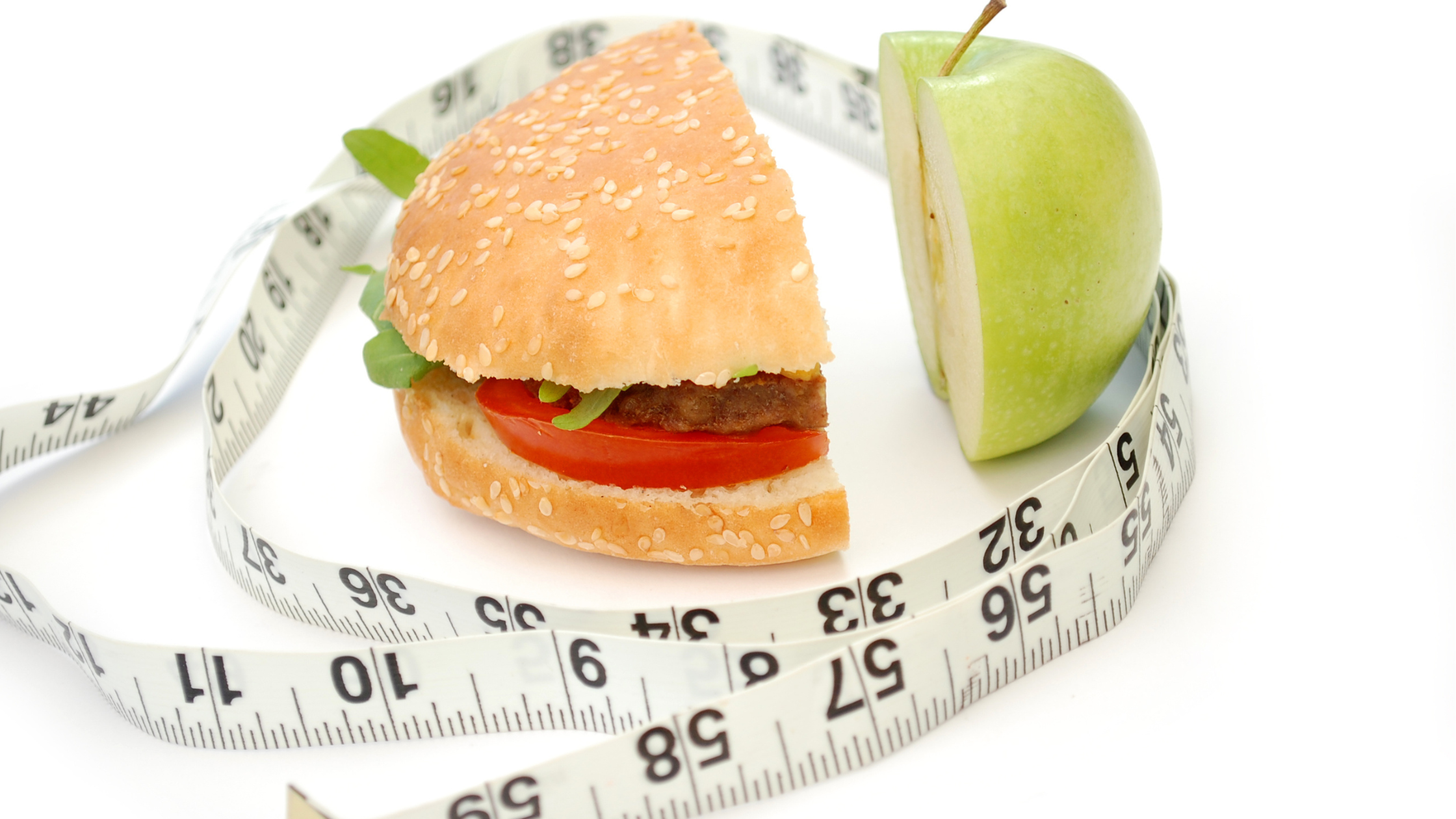 measuring tape wrapped around half of an apple and half of a hamburger