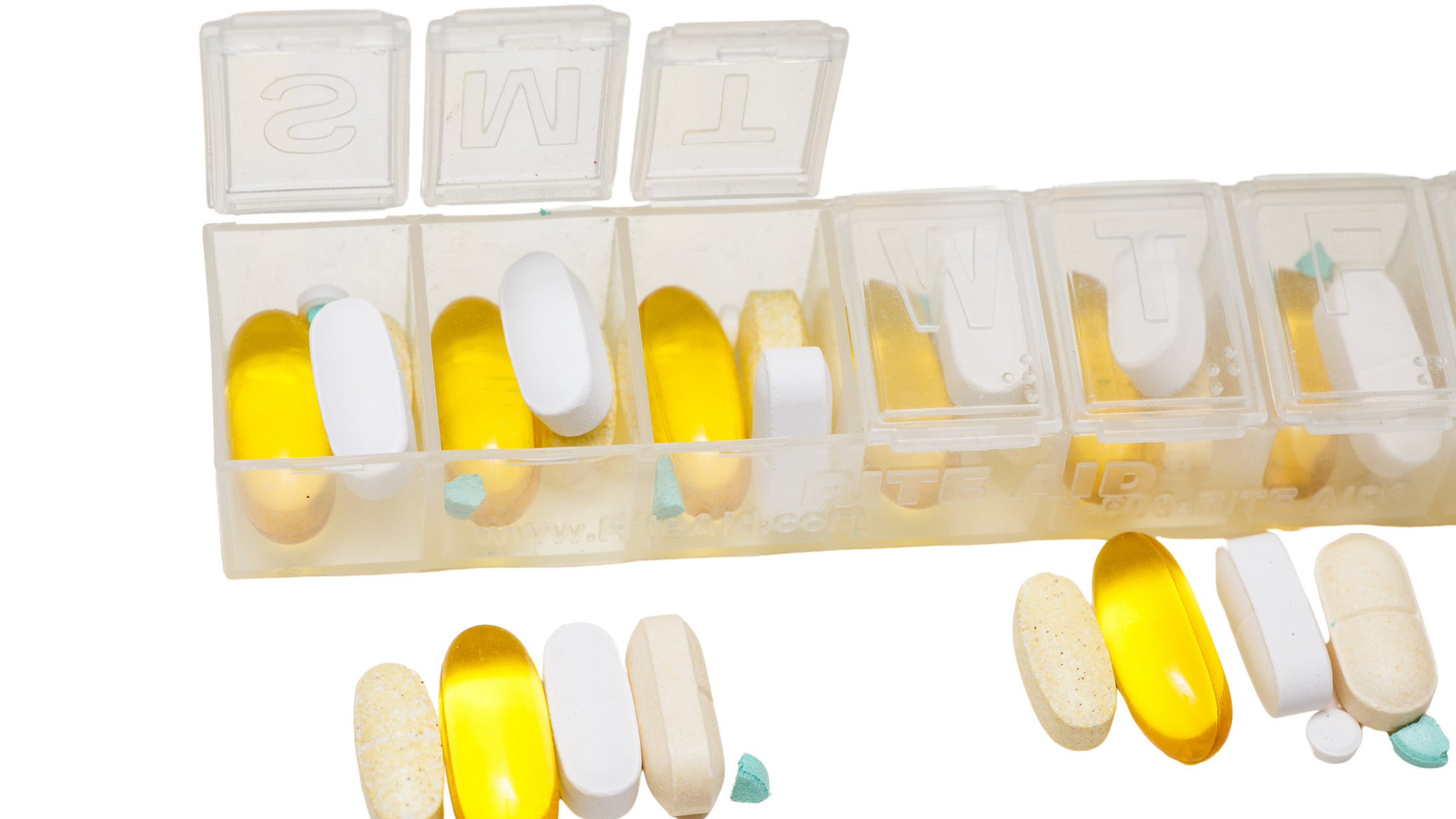 week-long pill planner with some pills in it and in front week-long pill planner with some pills in it and in front