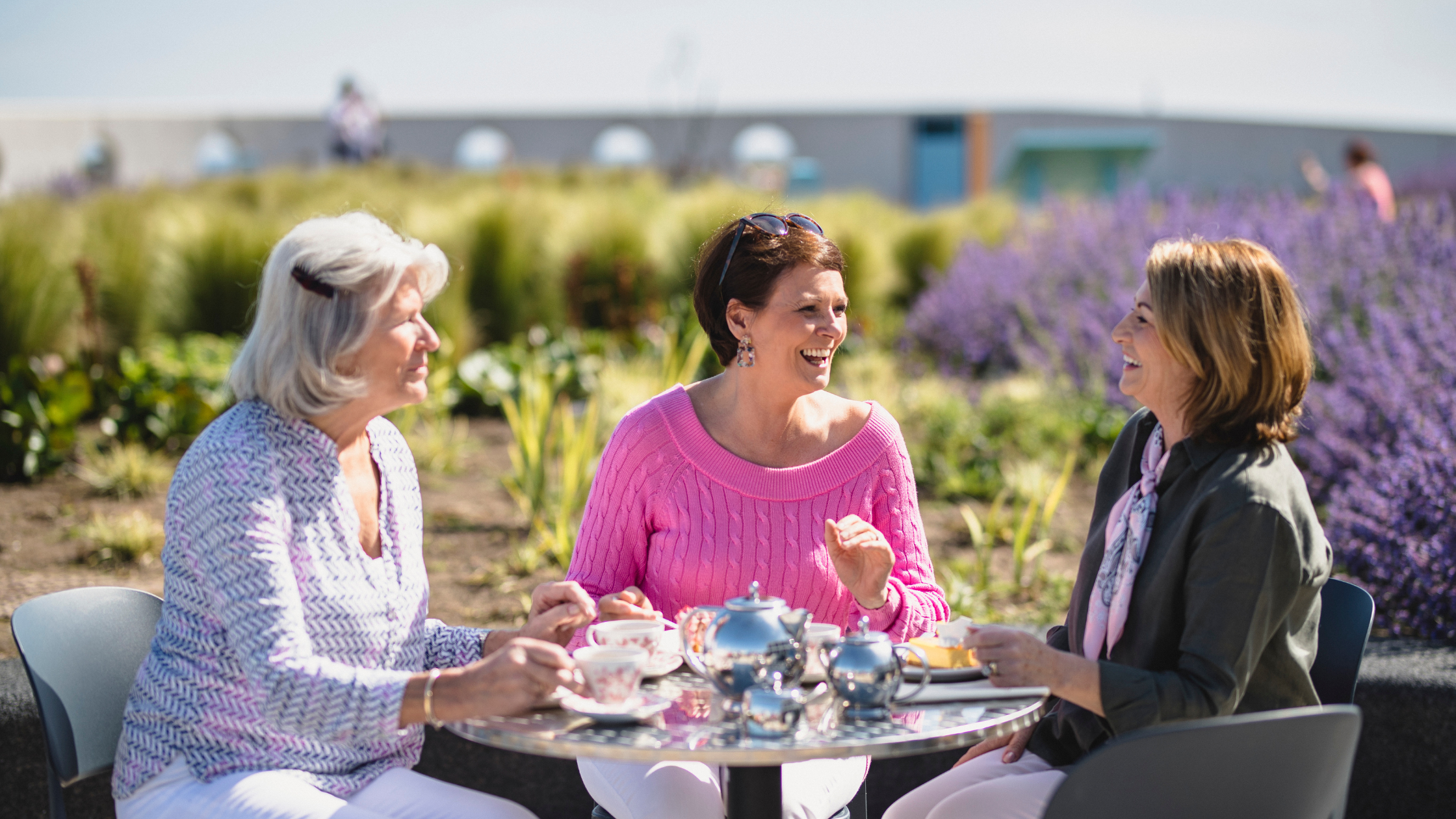 three senior women enjoy a meal outside