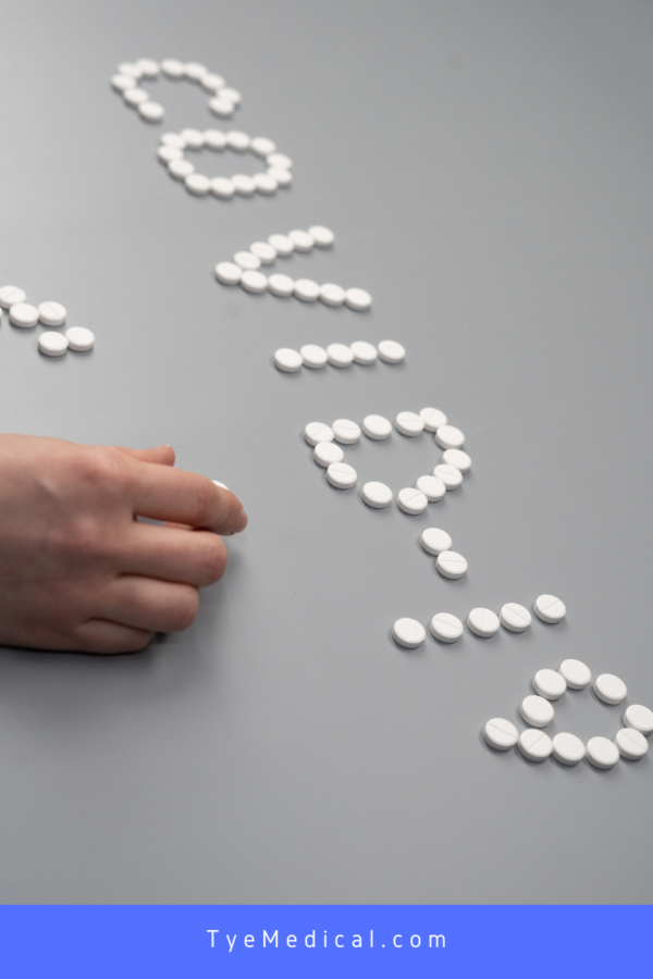 The word "COVID-19" spelled out with pill tablets