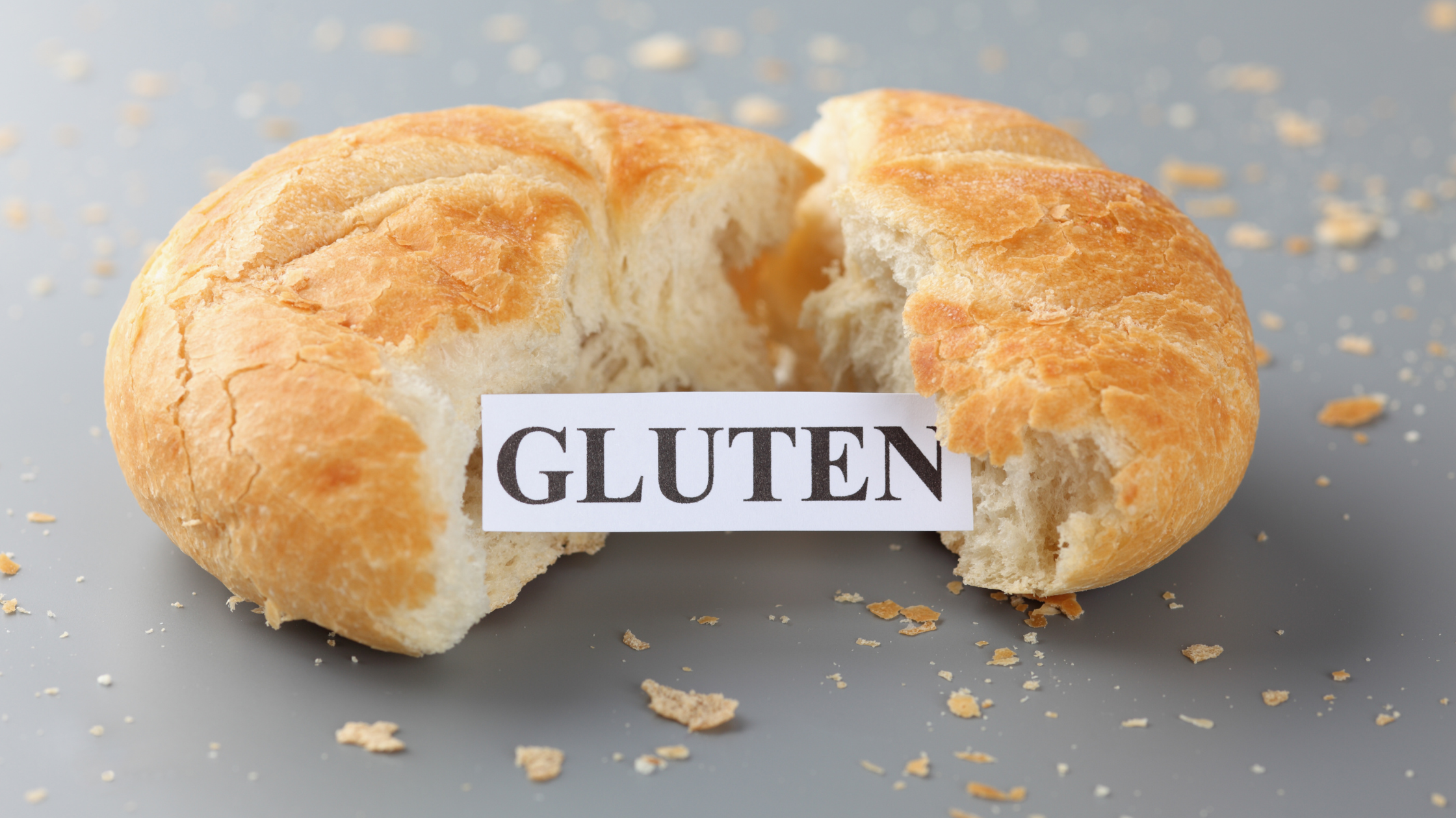 soft bread roll torn in half with a sign that says "gluten"