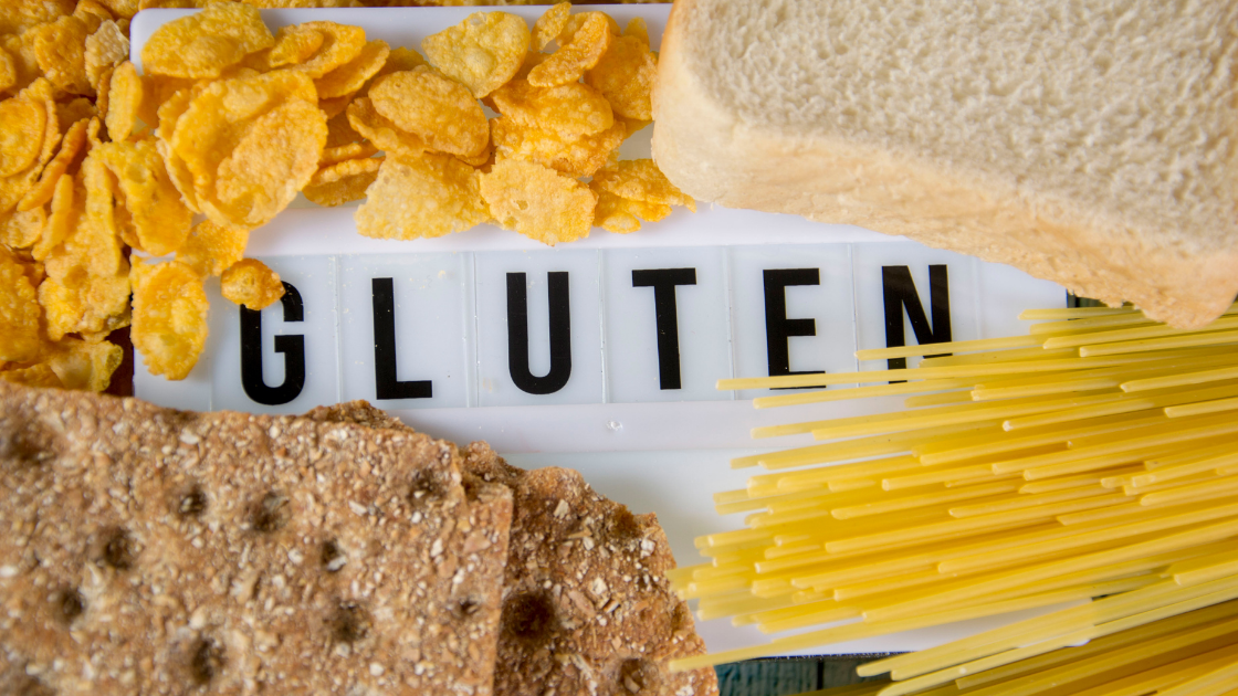 Board with the word "Gluten", cornflakes, breads, pasta