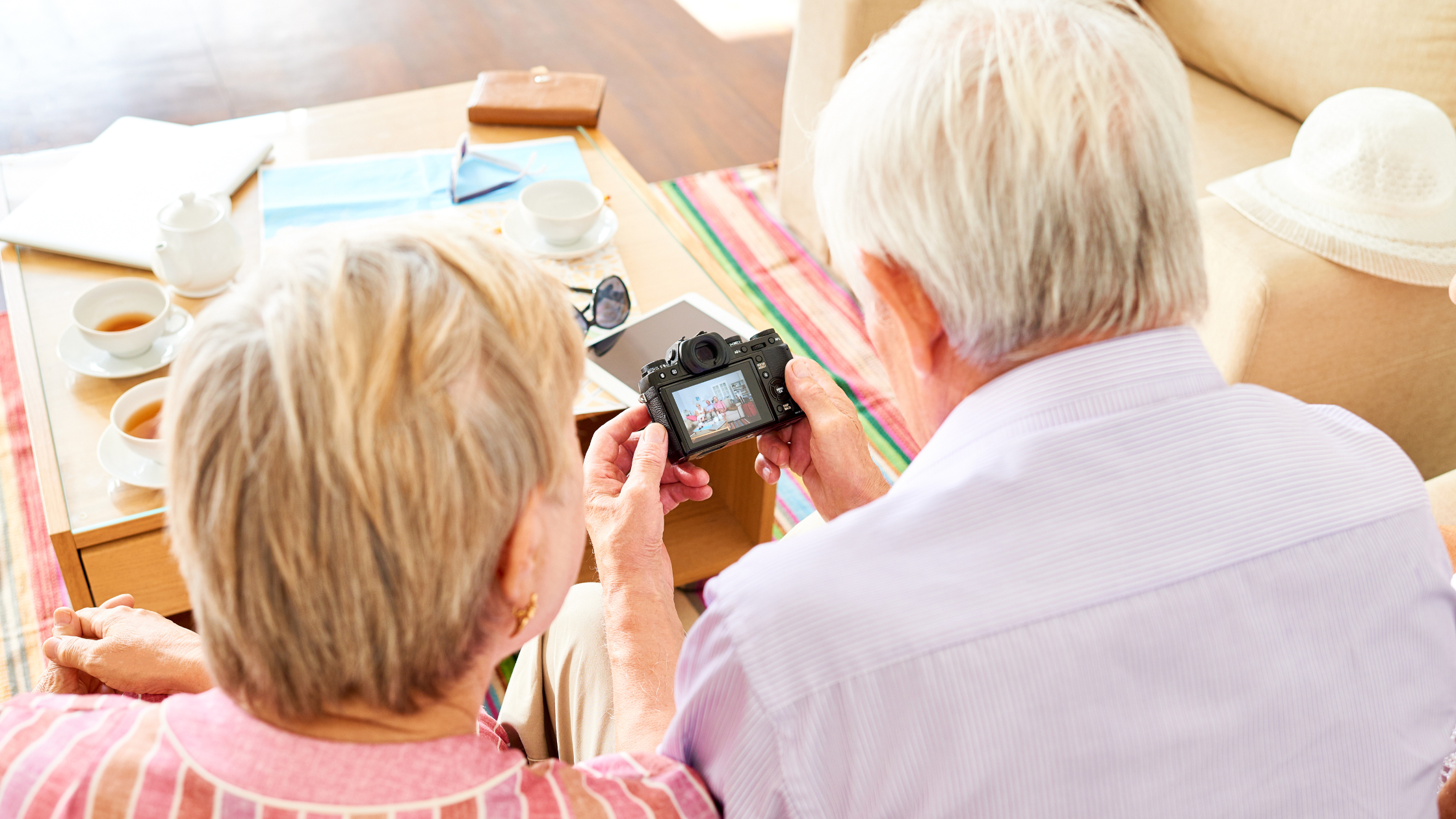 senior couple looking at photos on a digital camera together