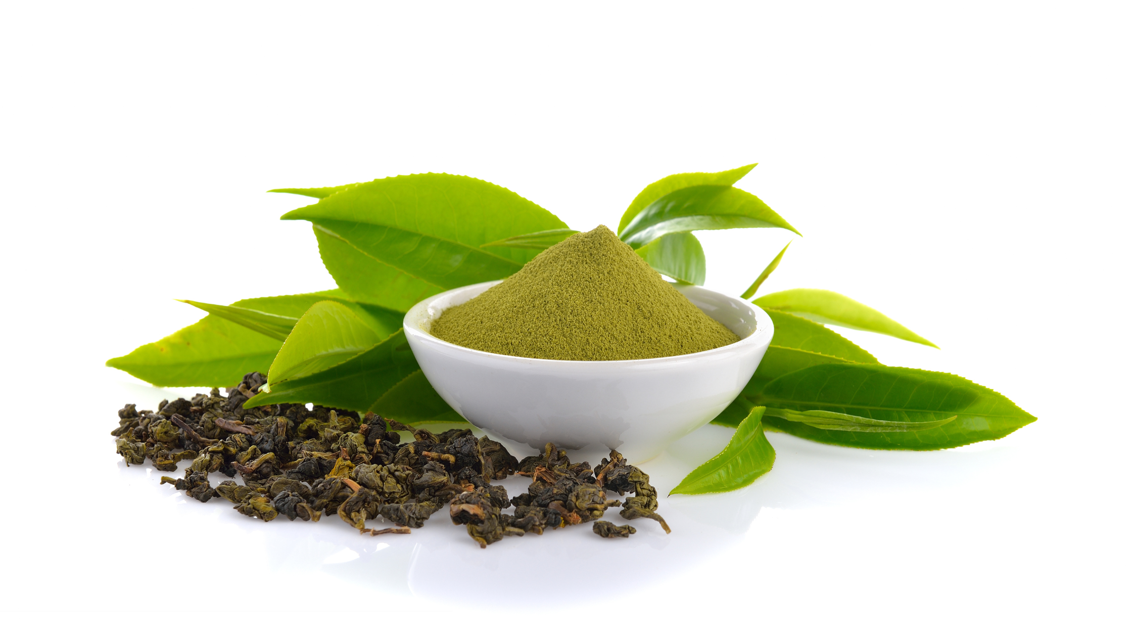 matcha powder in a bowl surrounded by leaves