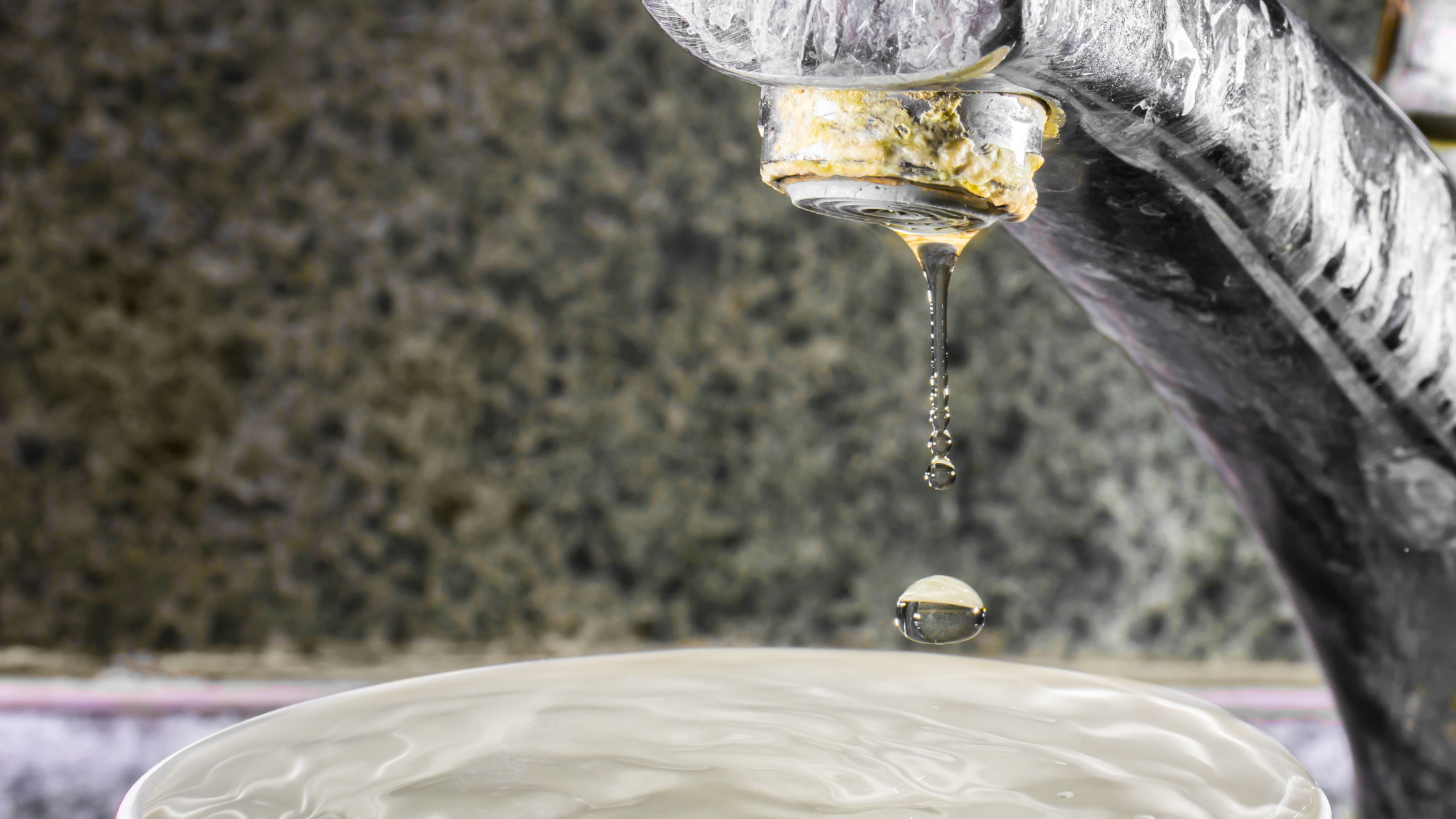 water faucet covered in stains and mineral deposits