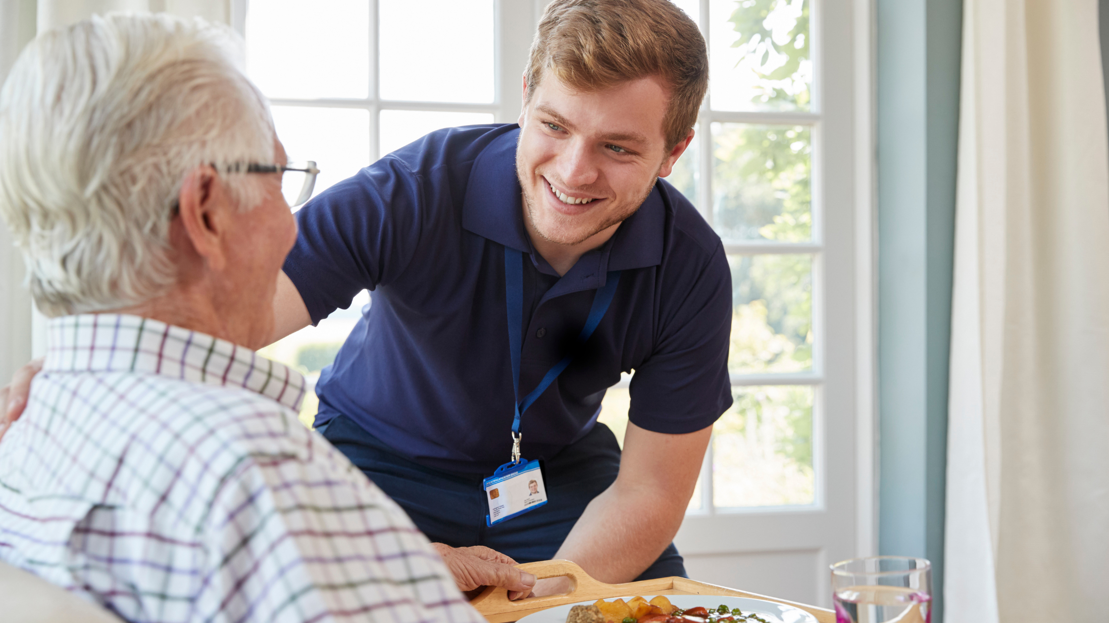 smiling aide talks to a senior man