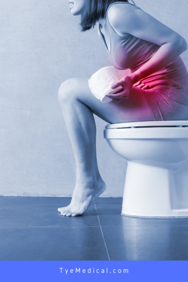 Woman on the toilet holds stomach in pain