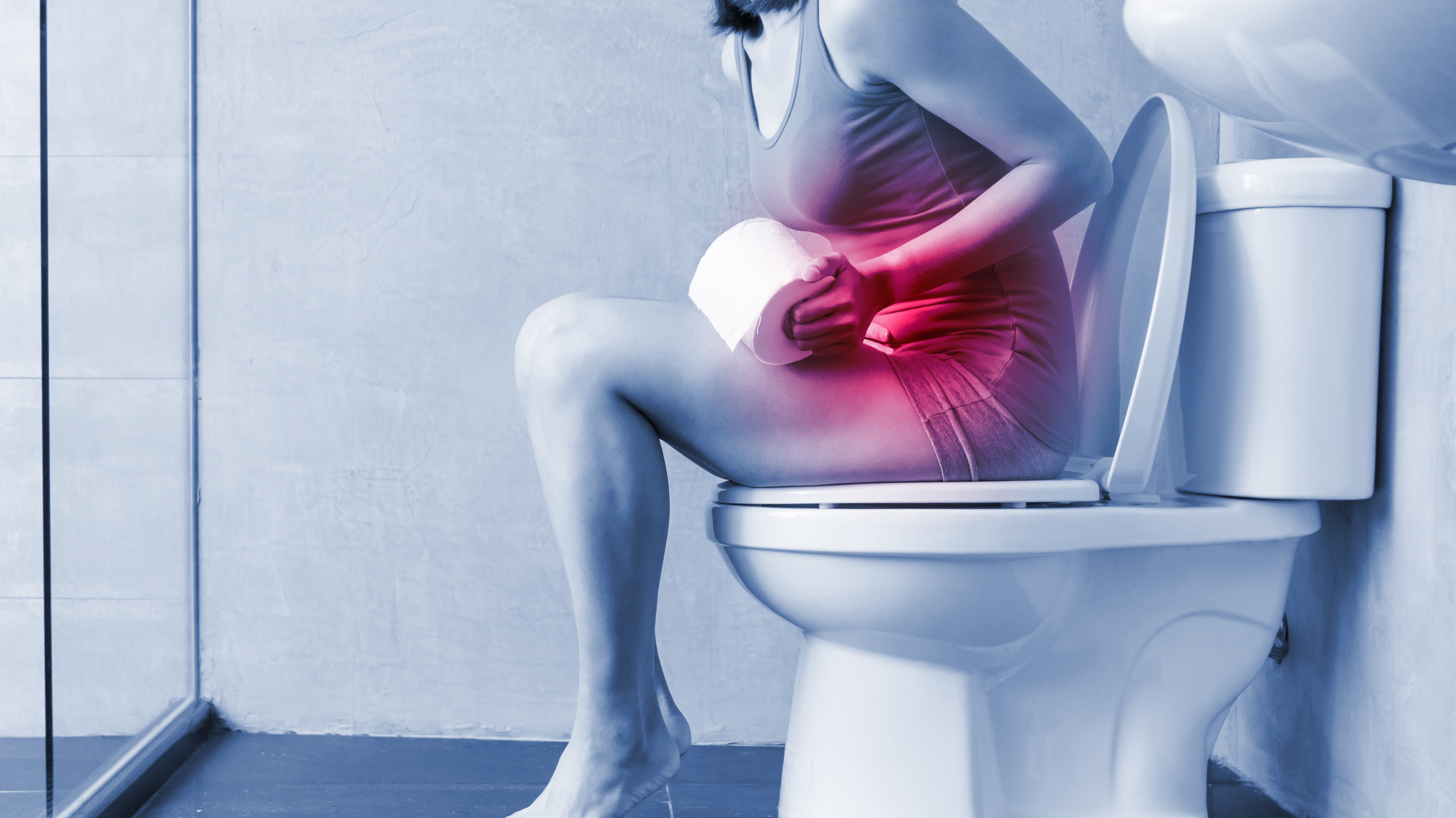 woman sitting on the toilet, stomach glowing red in pain