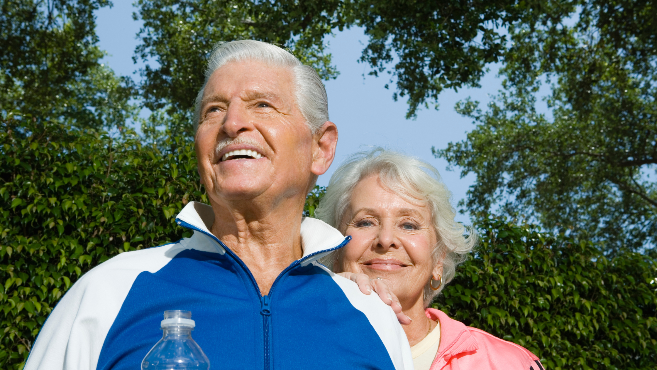 elderly couple walking outside wearing exercise clothing
