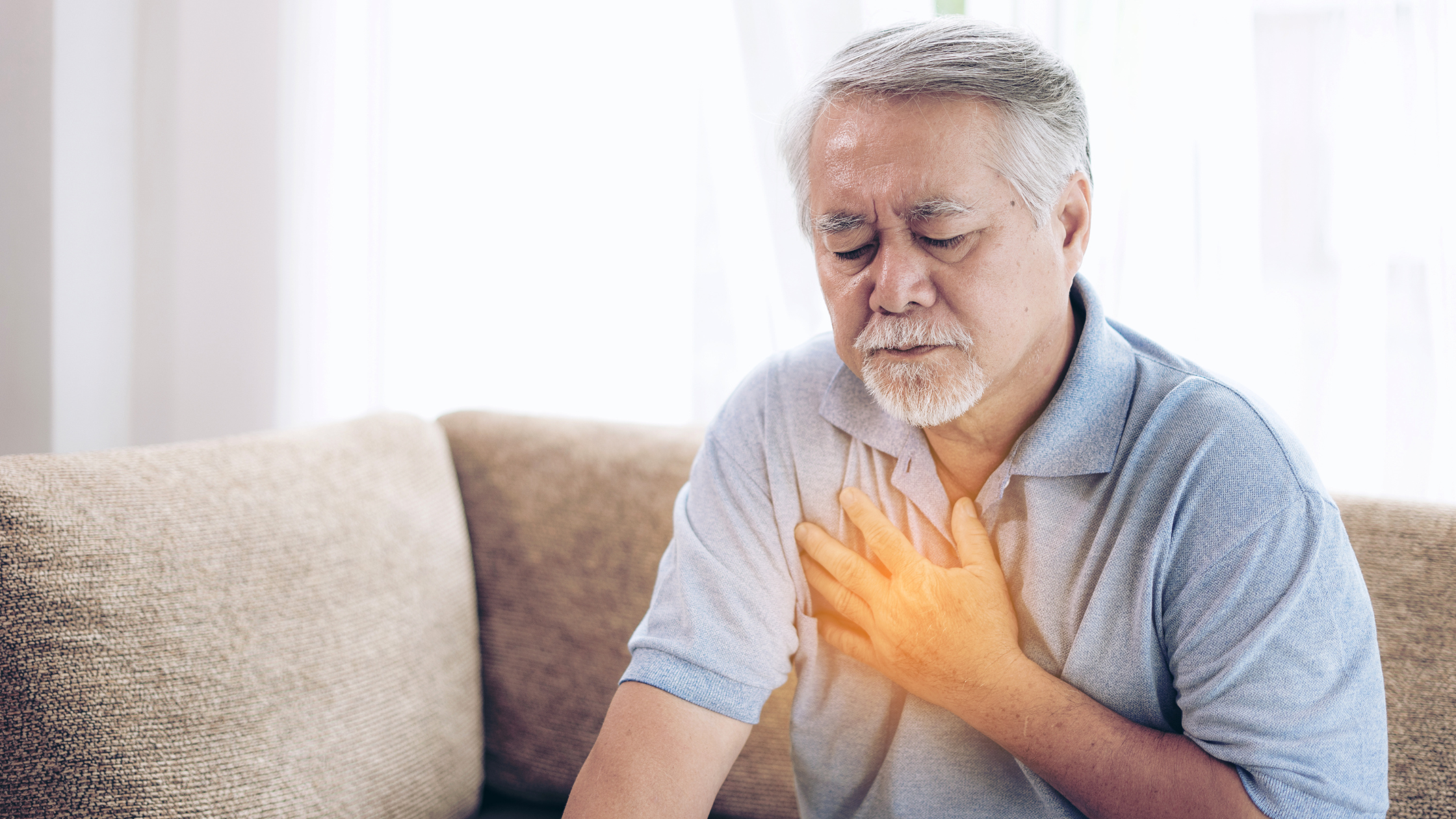 concerned-looking senior man places his hand over his glowing chest