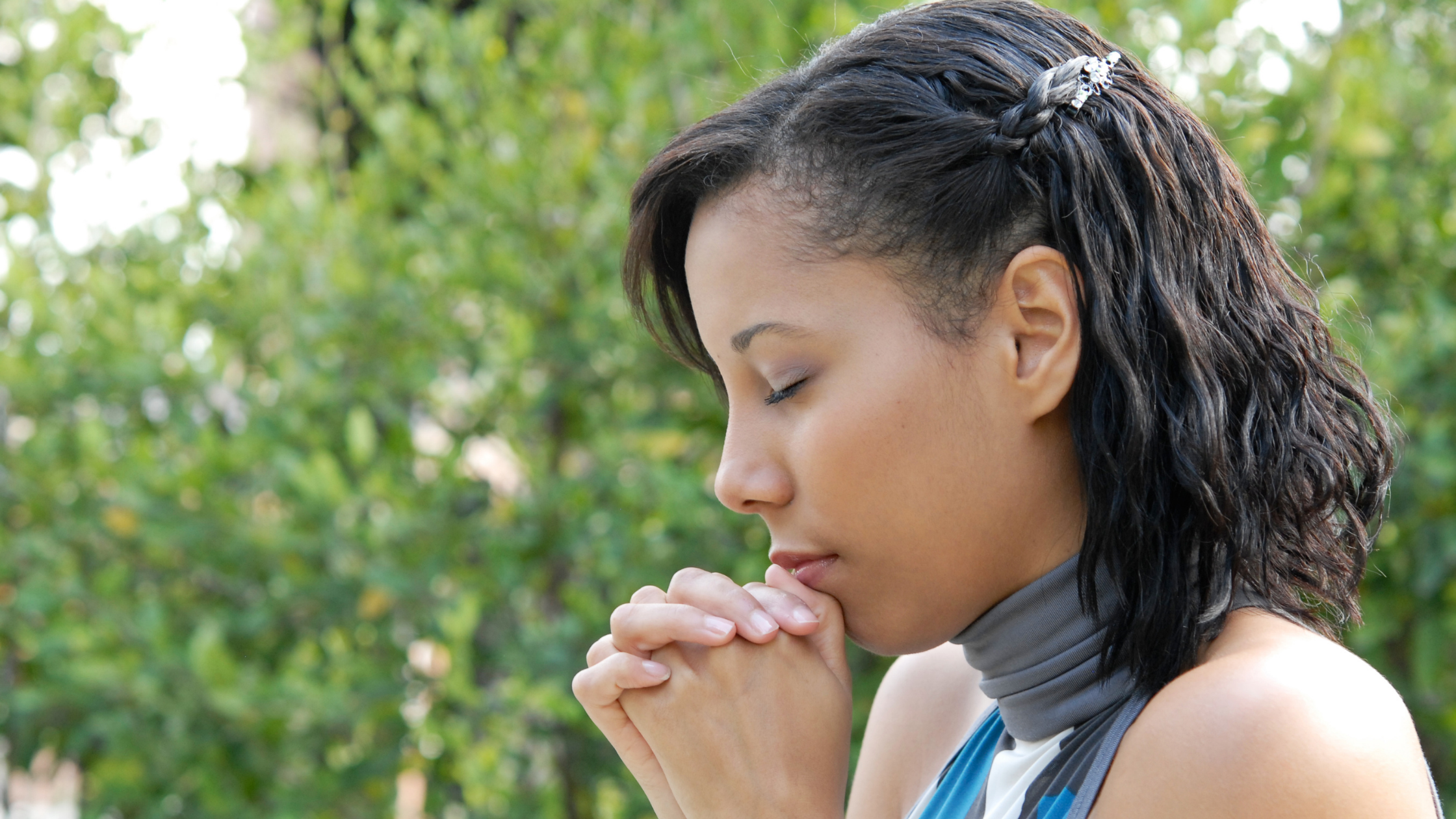 Woman praying peacefully outside in nature