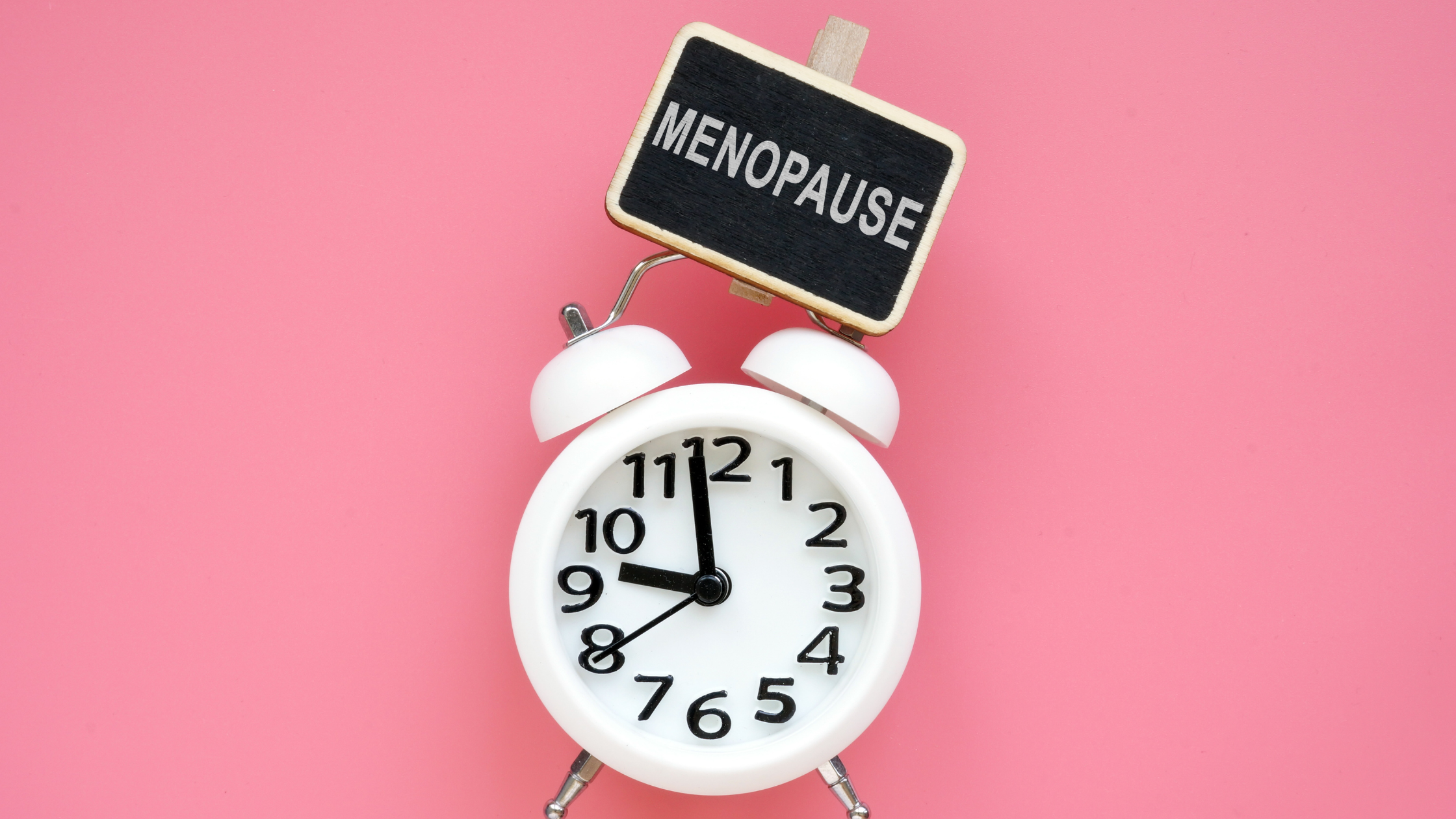 old fashioned alarm clock with a sign that says "menopause"