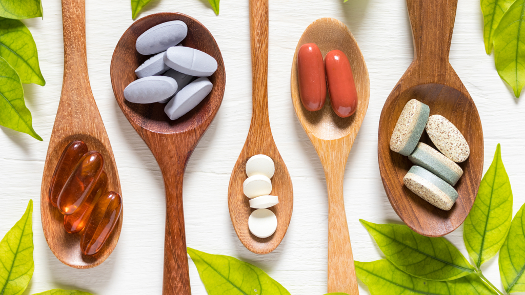 wooden spoons full of vitamins and herbal supplements