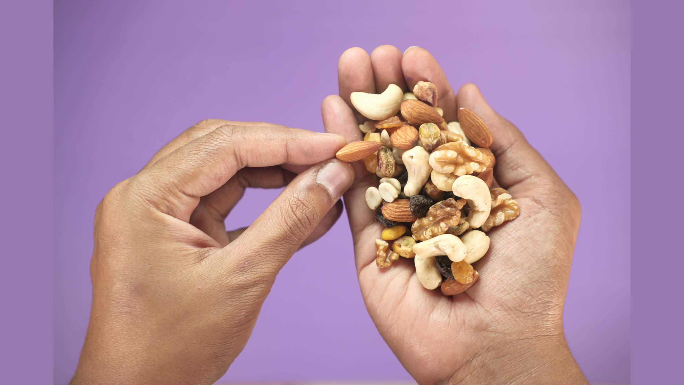 person with a handful of mixed nuts
