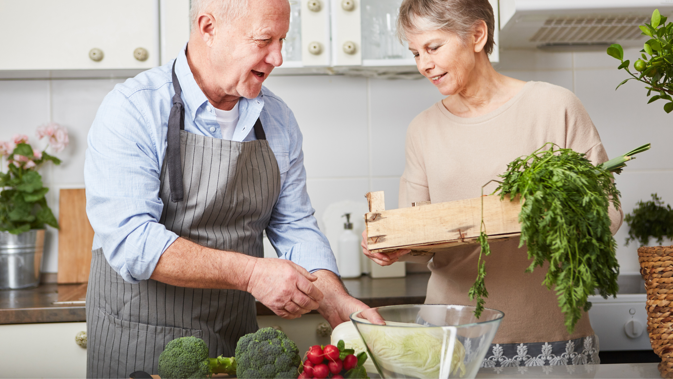 seniors stand in a kitchen in front of a bunch of fresh vegetables