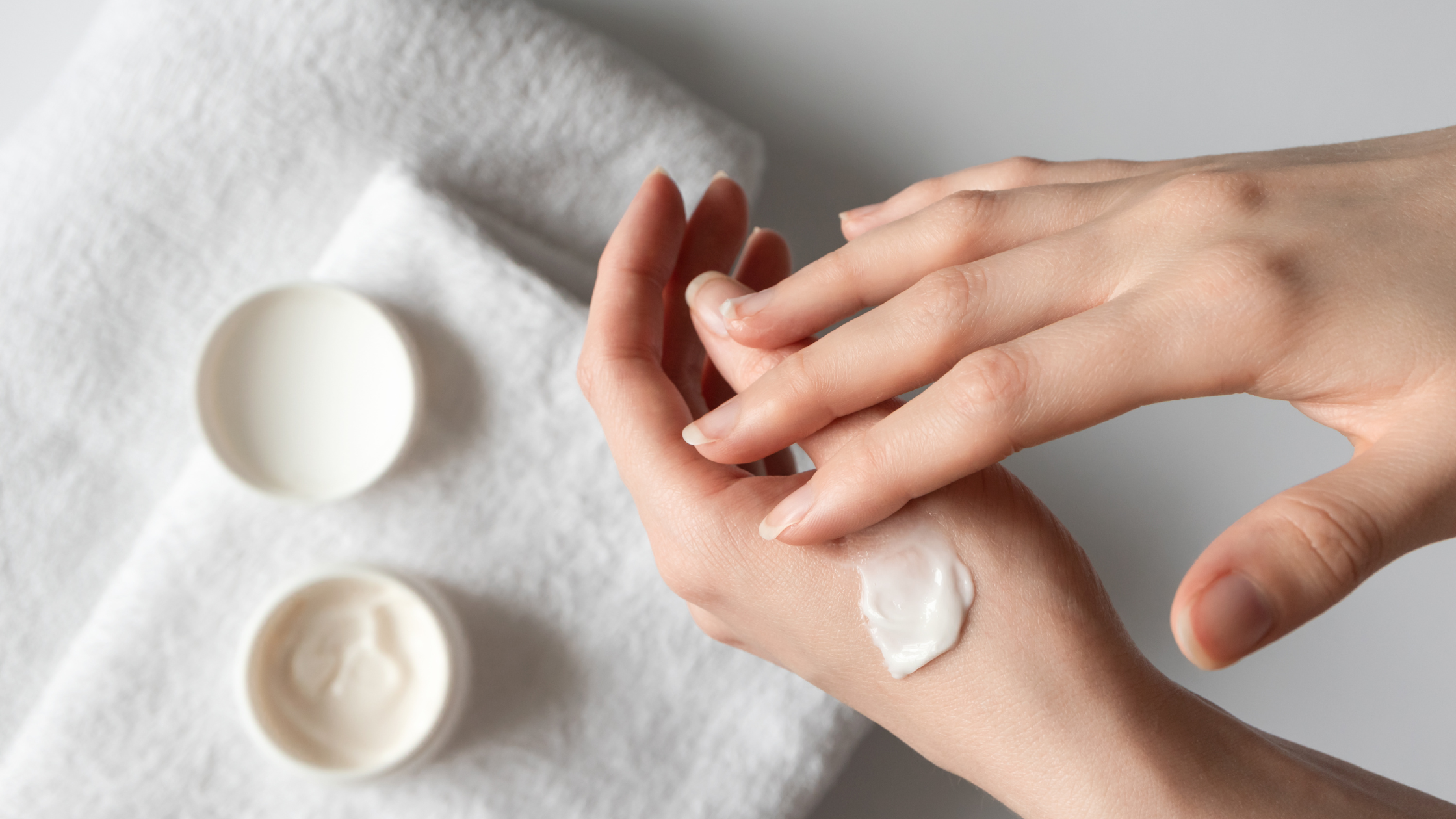 open tub of hand cream with someone applying it to themselves