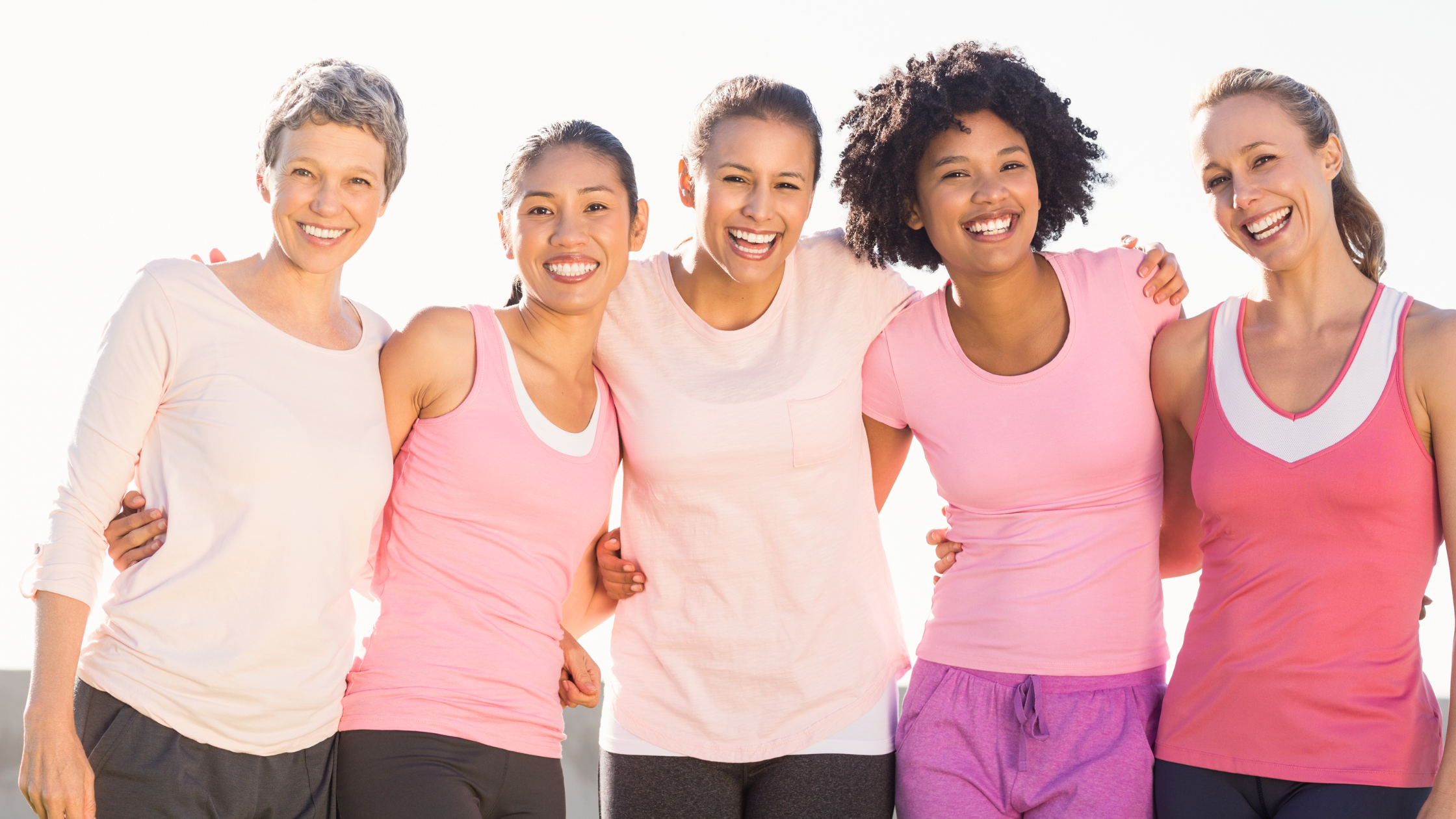 line of smiling women stand arm-in-arm