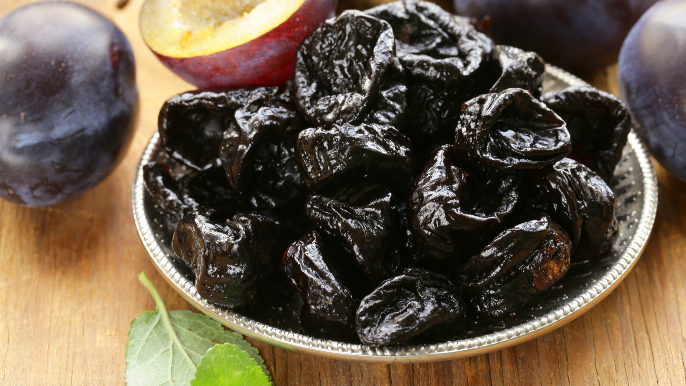 plate of prunes surrounded by fresh plums