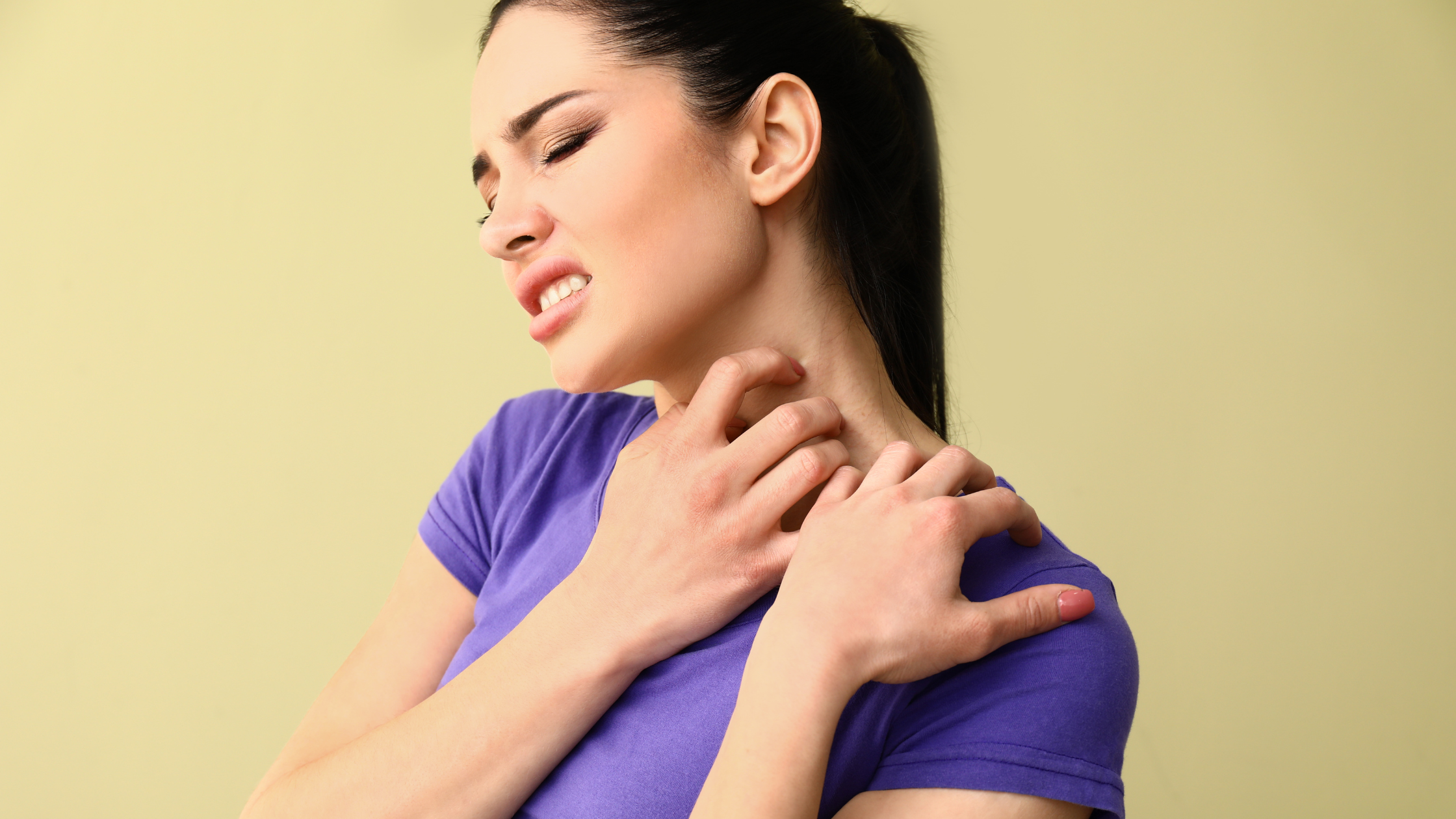 woman grimacing as she scratches her neck