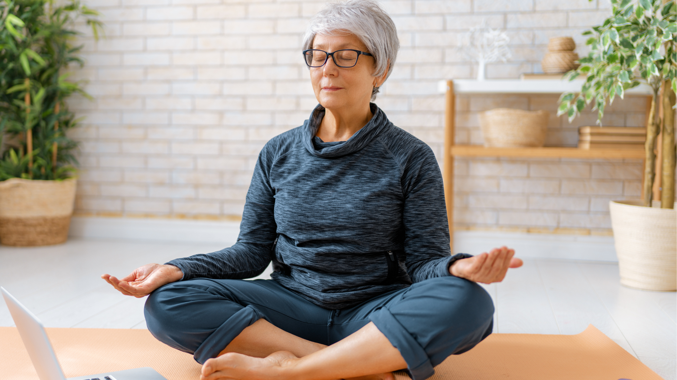 senior woman meditates sitting cross-legged