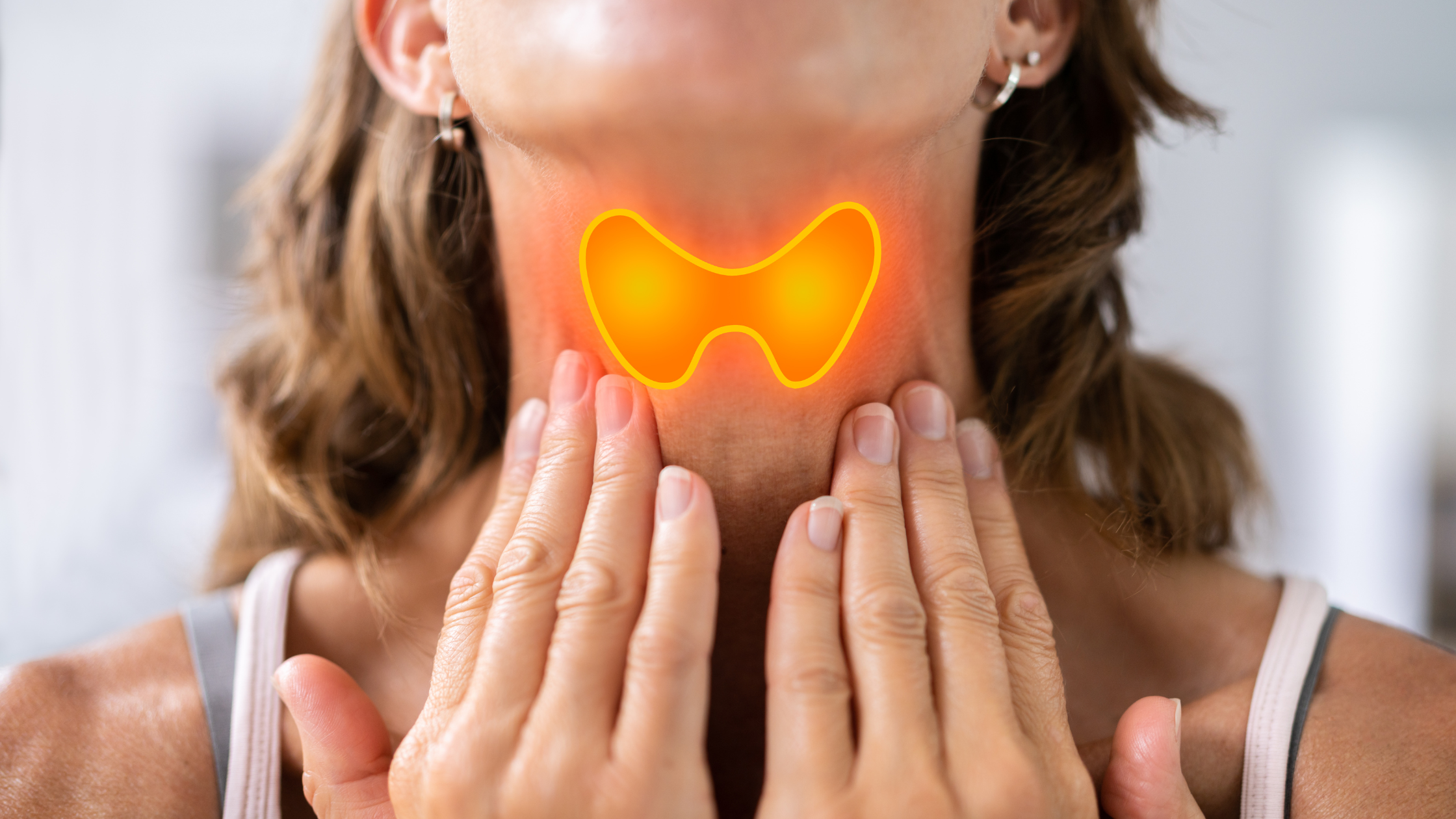woman holds both hands to her throat, thyroid glands glowing through her skin