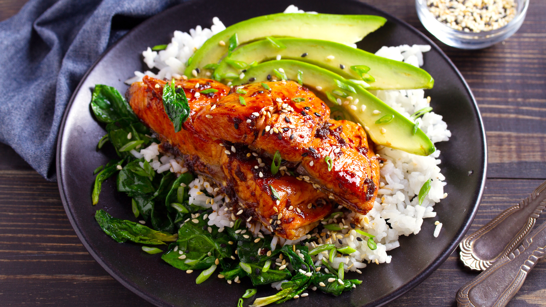 meal of salmon on a bed of rice and greens