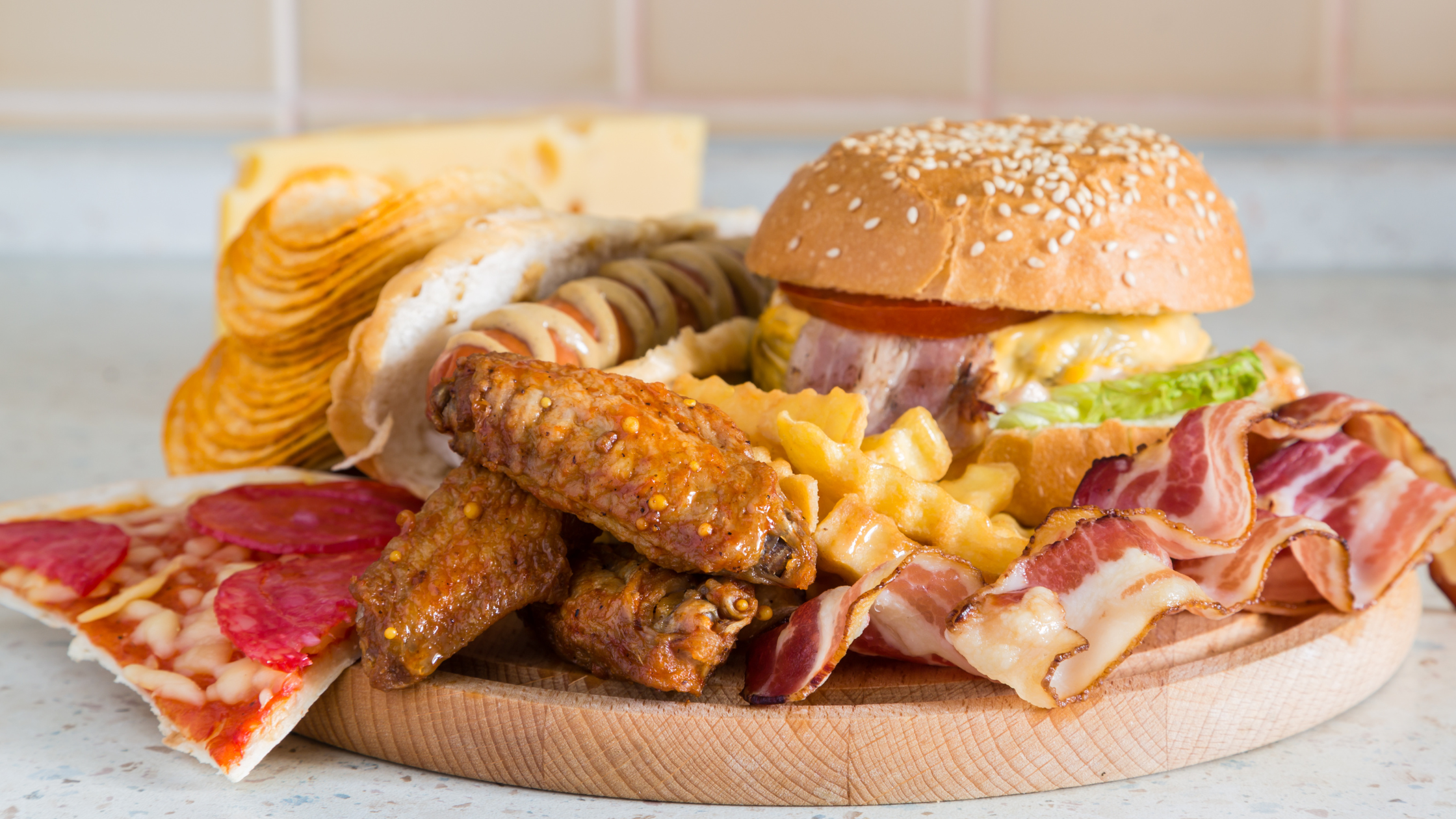 plate piles high with bacon, pizza, chips, fries, and burgers