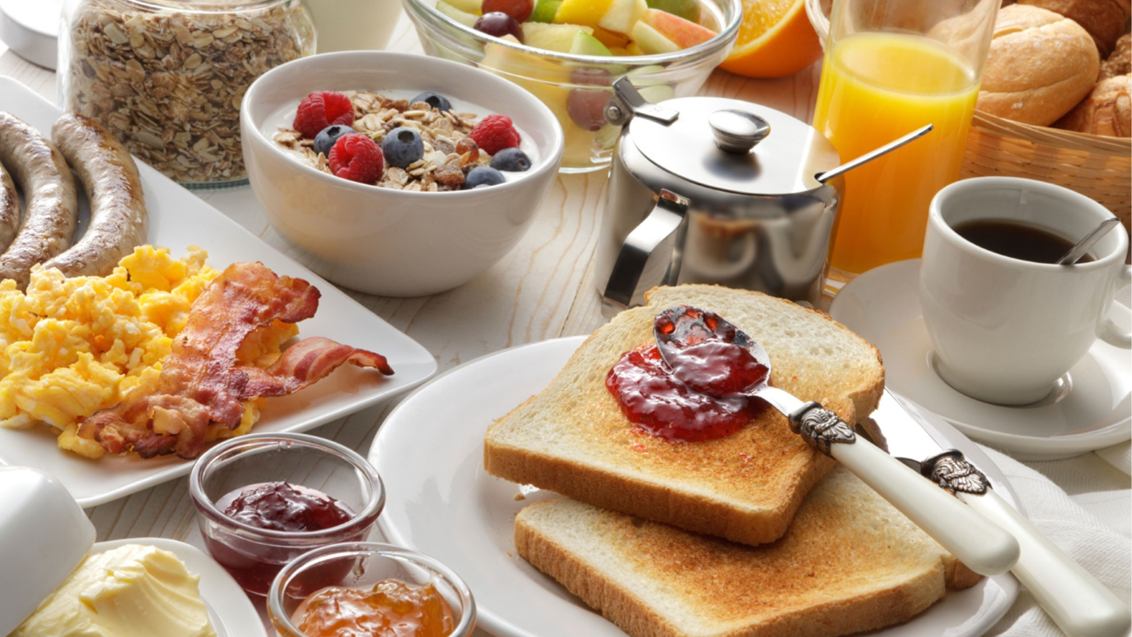 table covered in breakfast foods and drinks