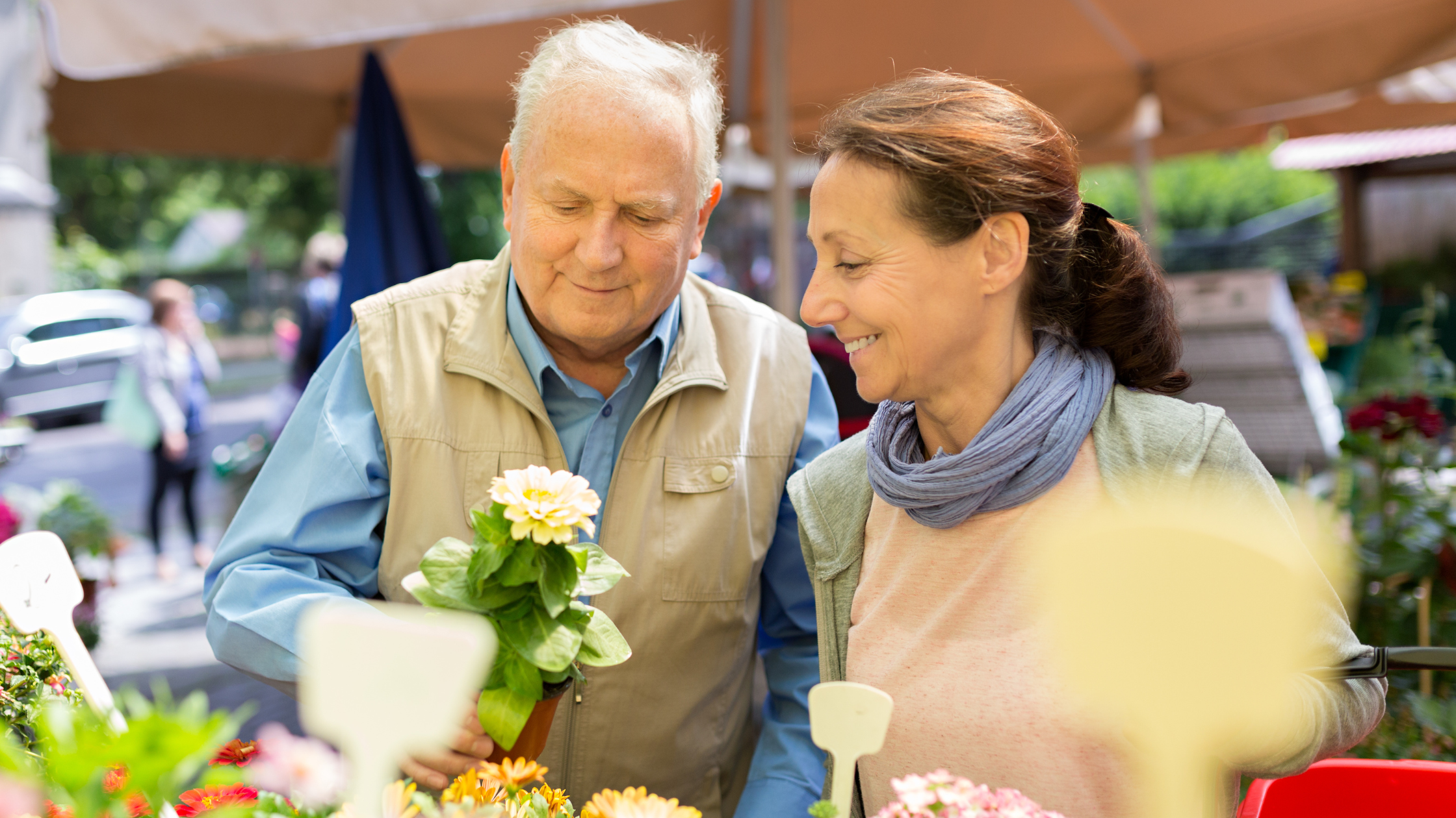 seniors at a farmer's market smiling at flowers