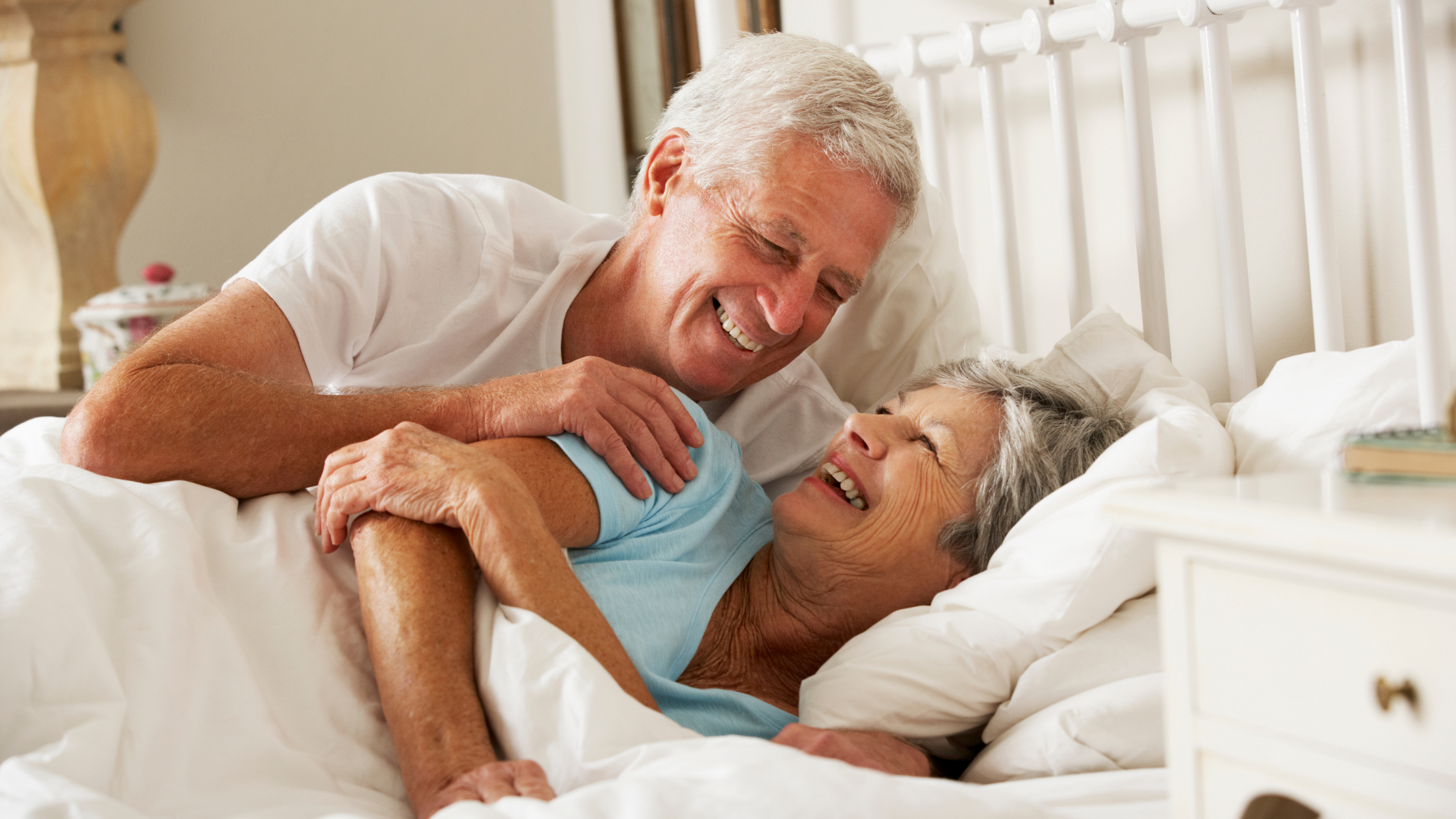 Happy Older Couple in bed laughing