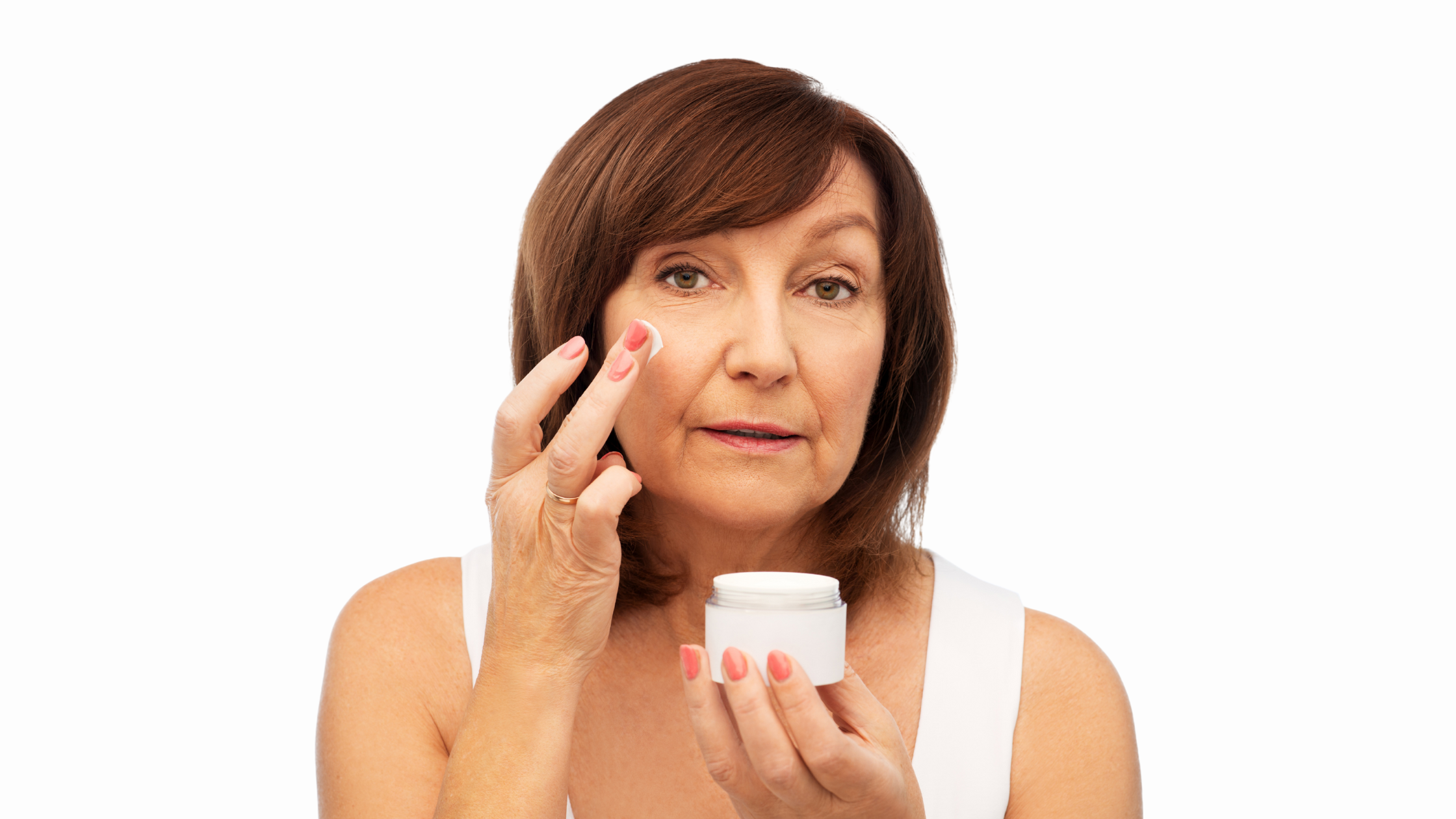 senior woman applies a cream to her face
