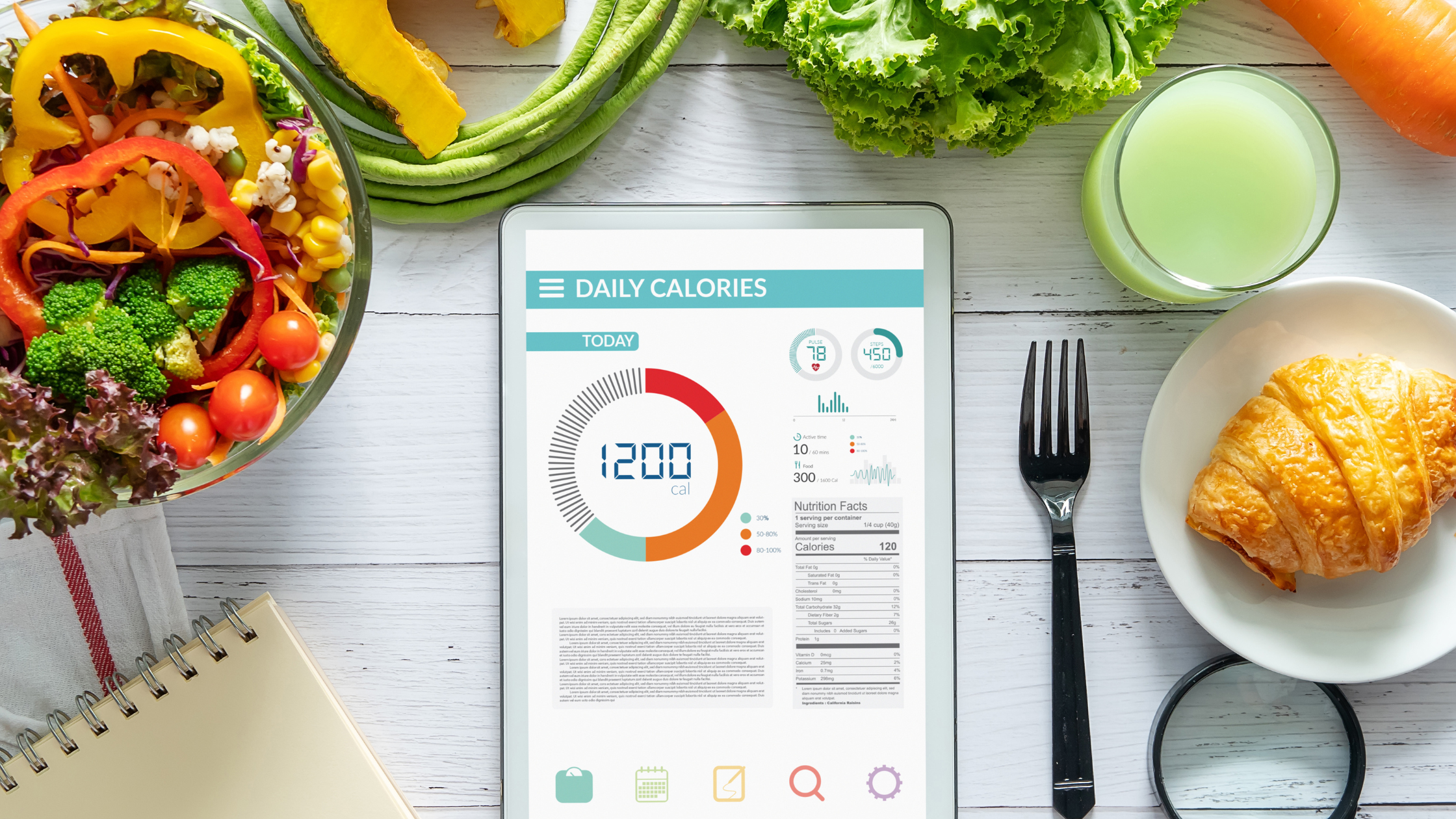 ipad screen open to a calorie-counting app, surrounded by vegetables