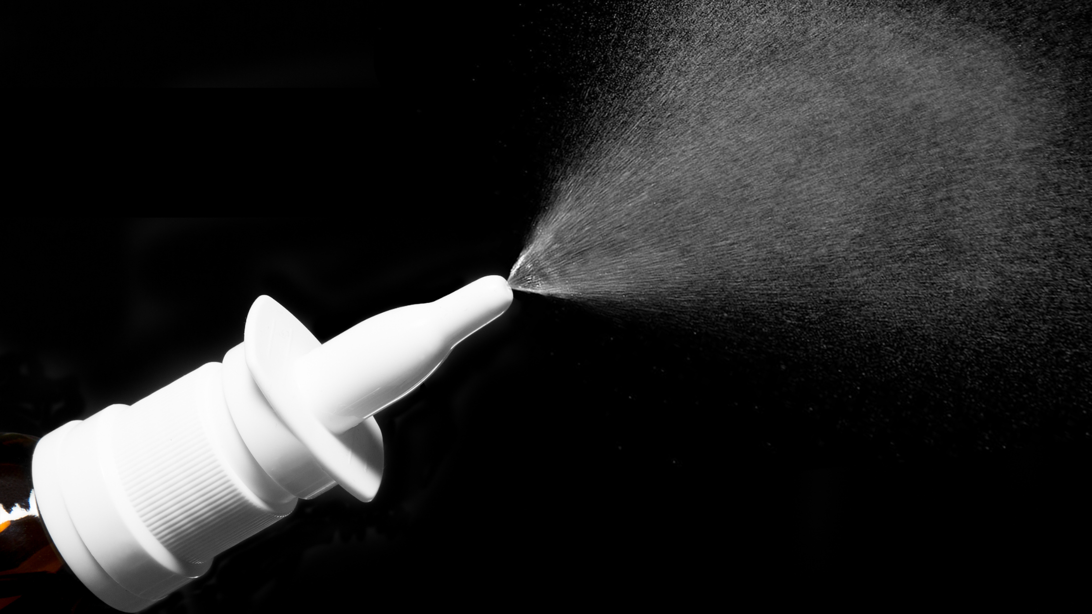 bottle of nasal spray being shot into the air