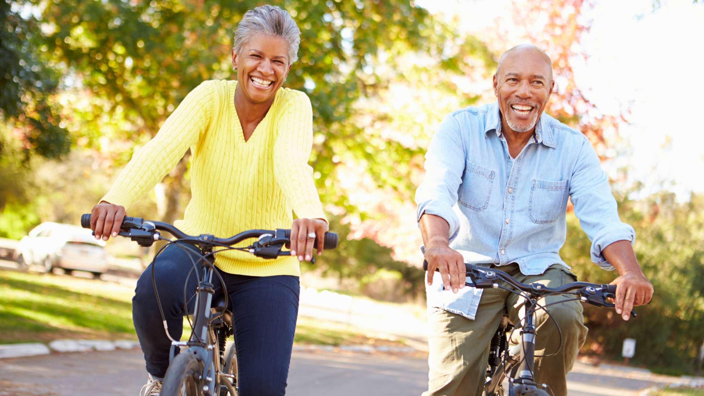 smiling seniors riding bikes in the sunshine