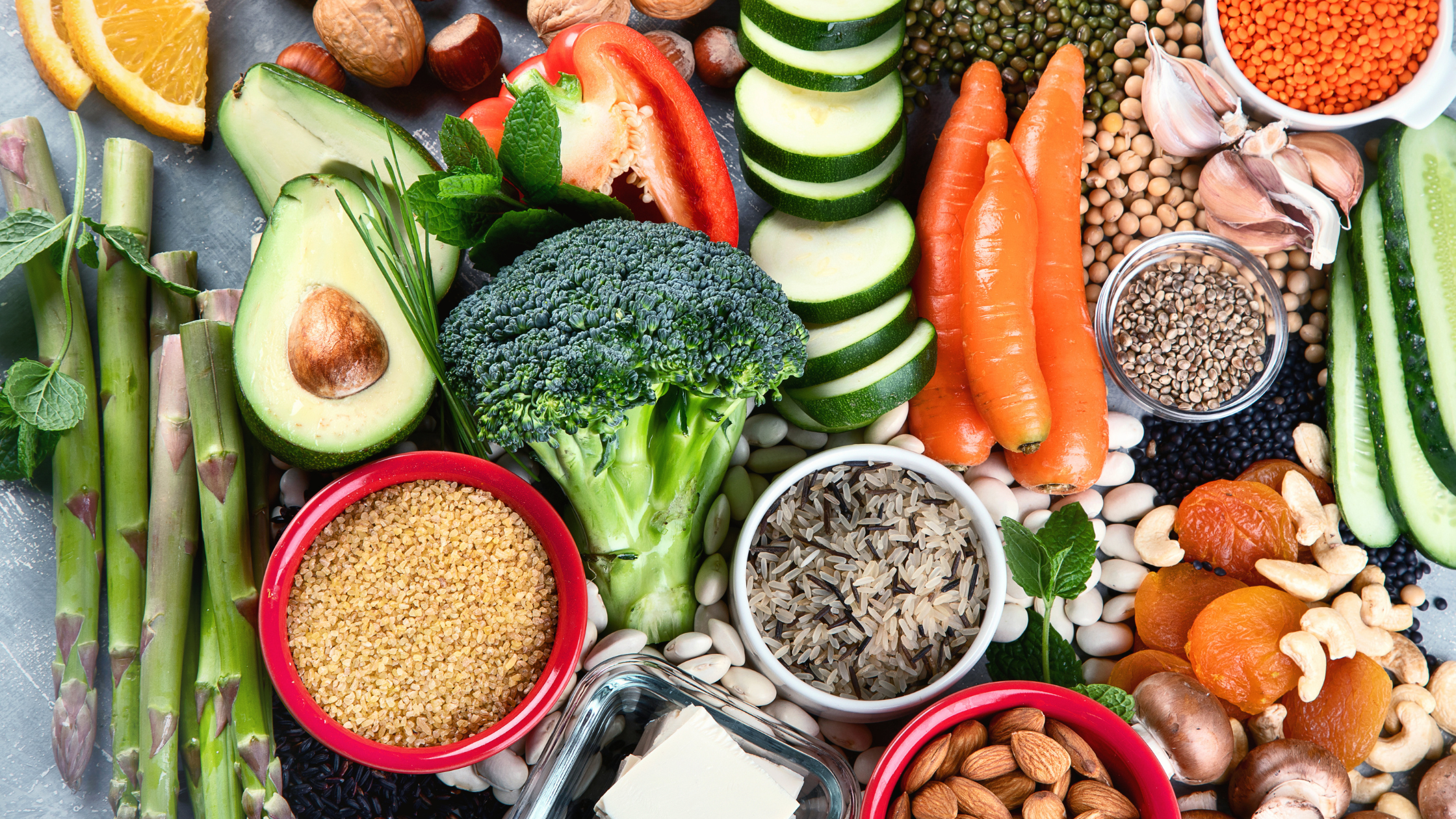 top-down view of a tabletop covered in fruits, veggies, nuts, and grains